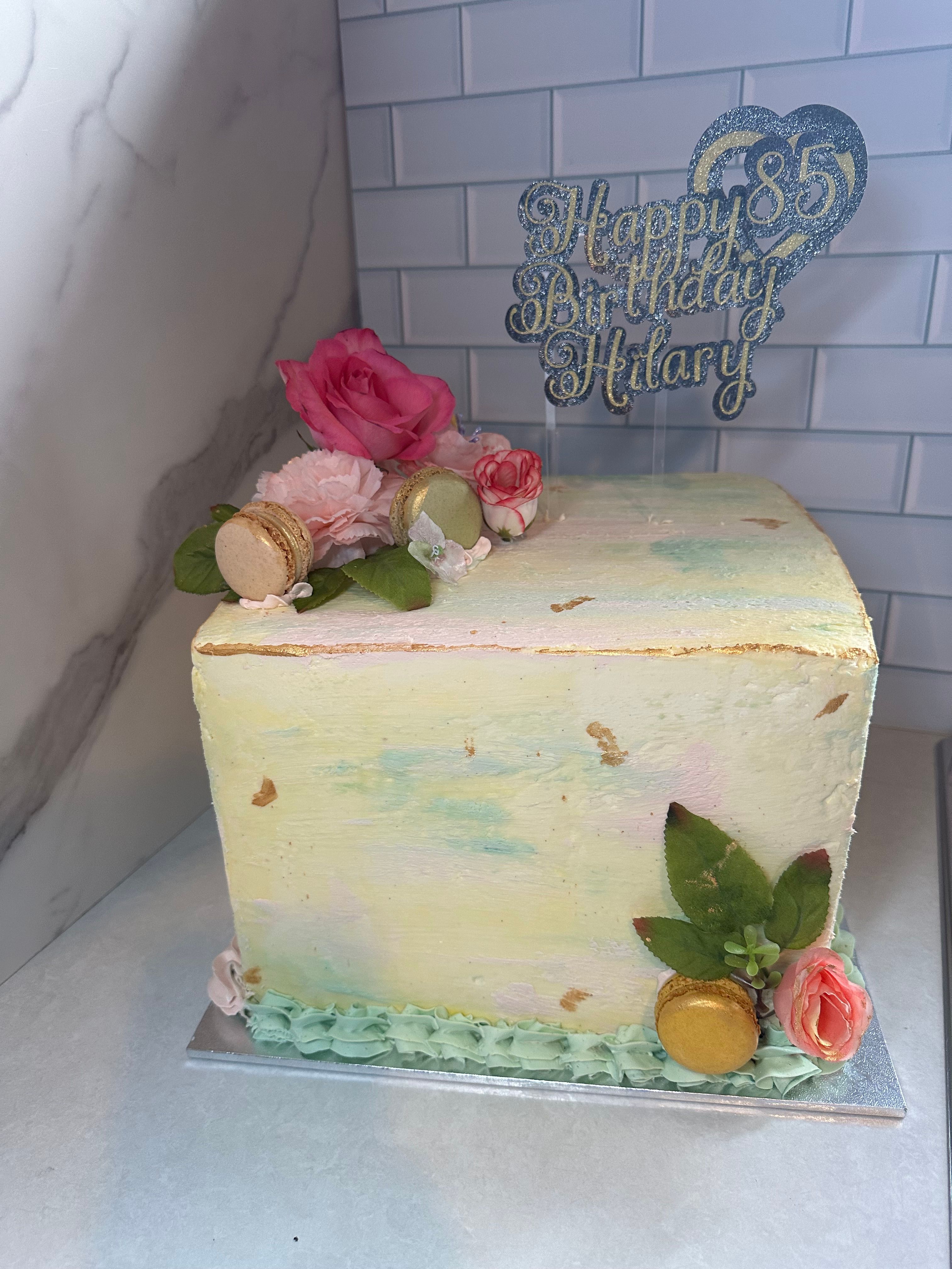 Square 85th birthday cake with watercolour buttercream, roses and macarons
