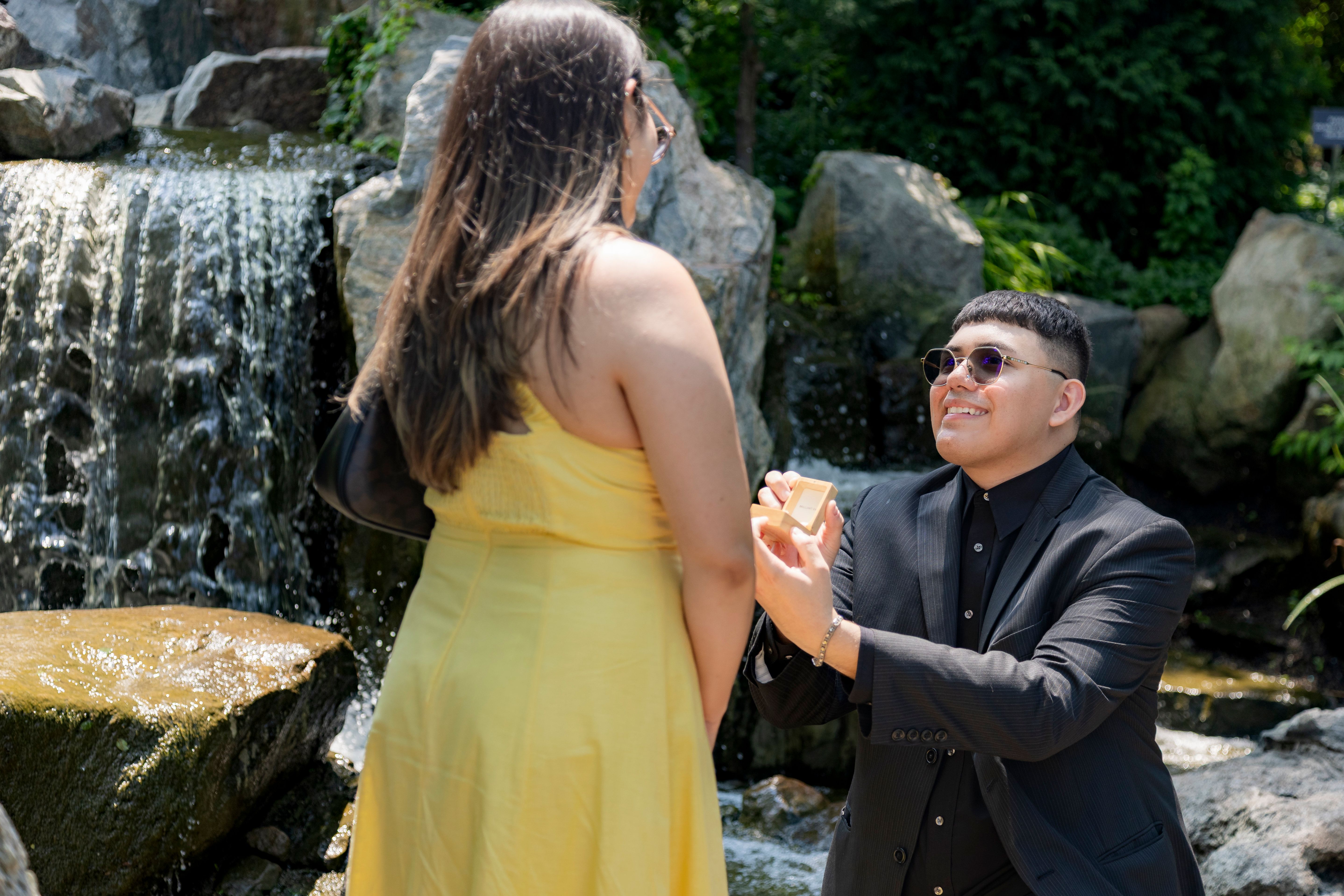 Marriage proposal kneeling moment with waterfall