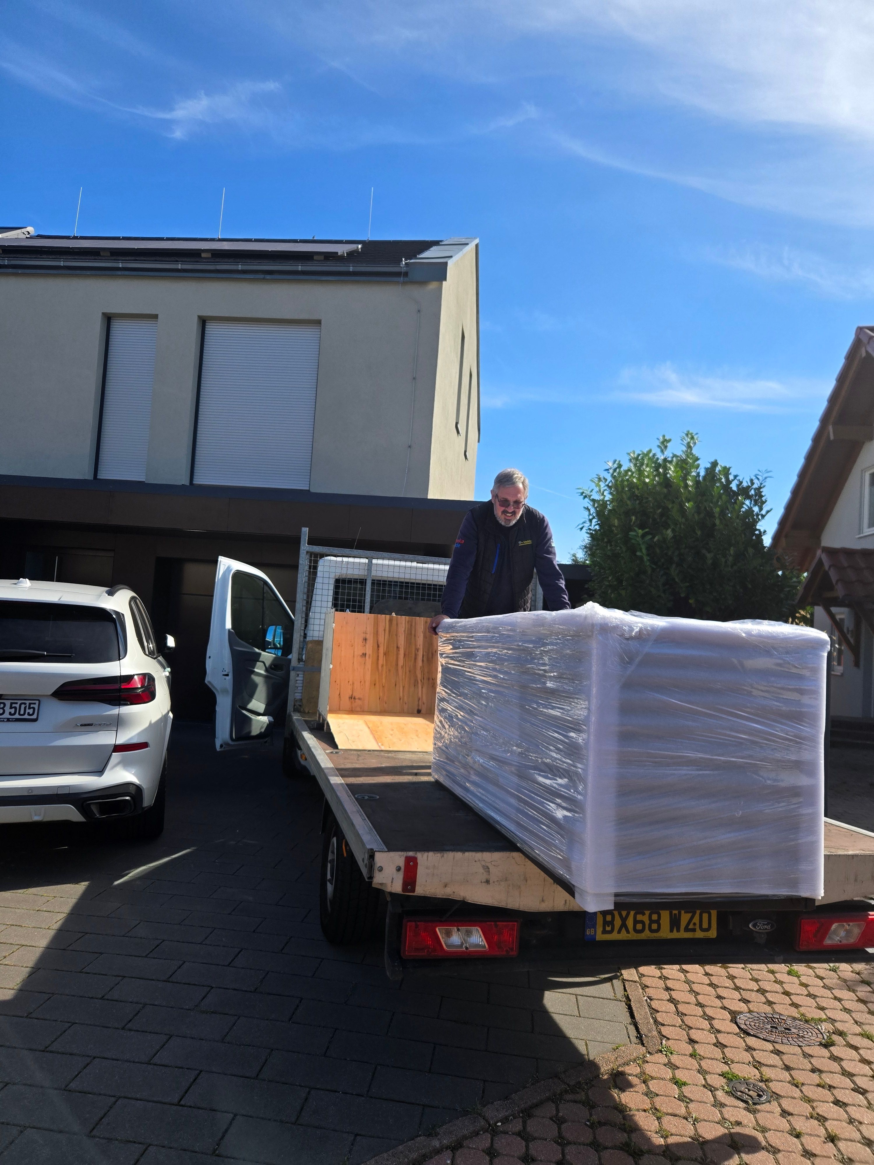 Technician standing with wrapped hot tub on trailer