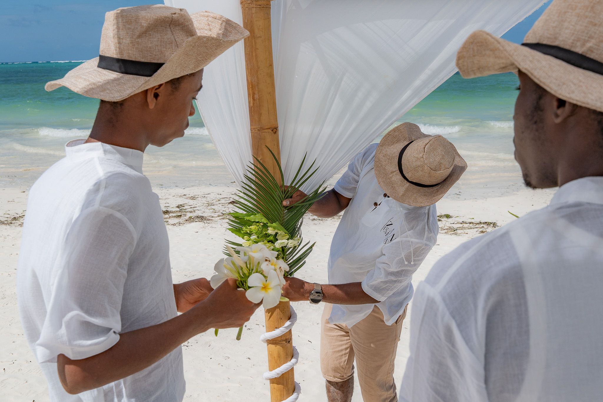 Our team hand-placing fresh flowers on the ceremony setup