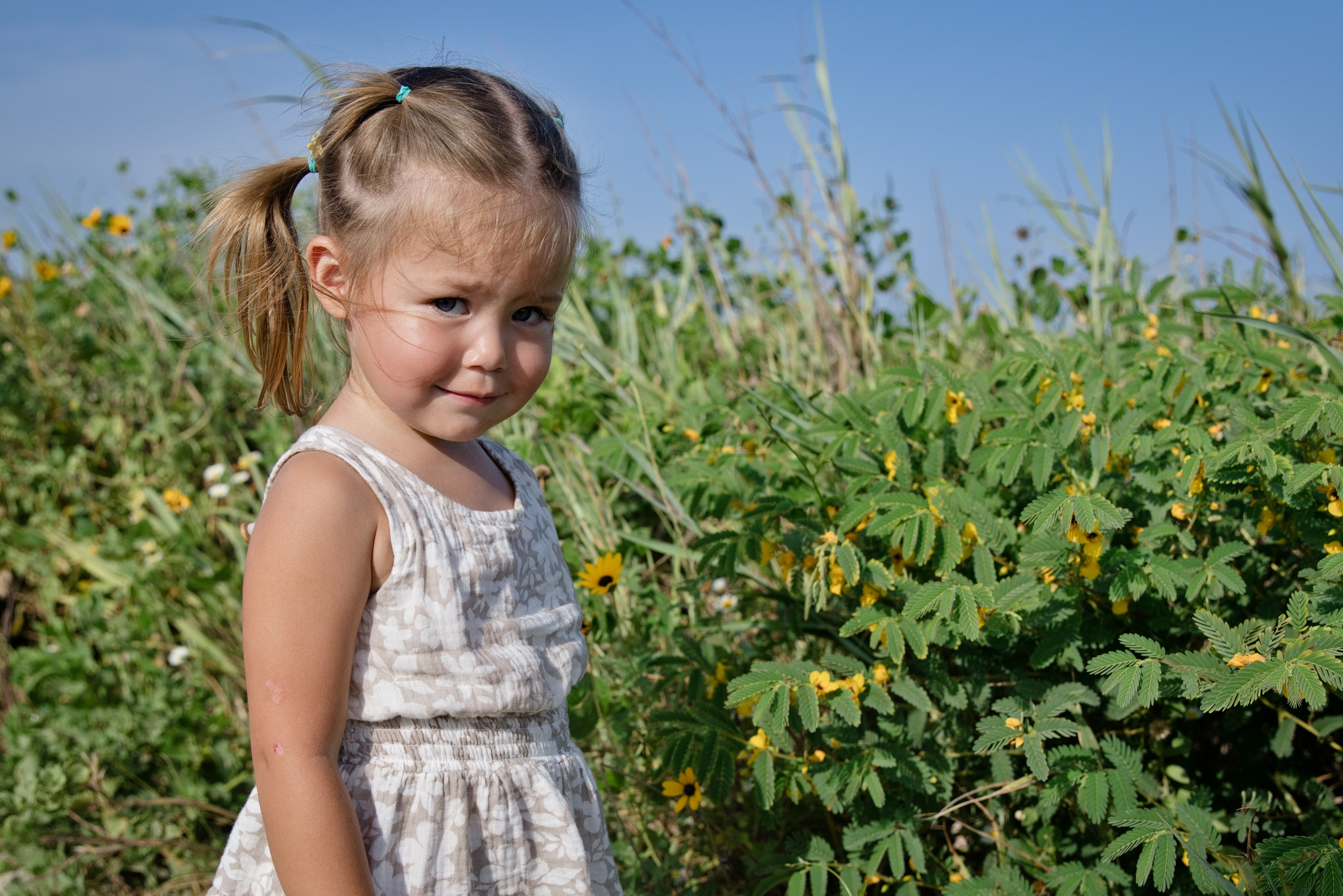 Little girl in a floral dress on the beach