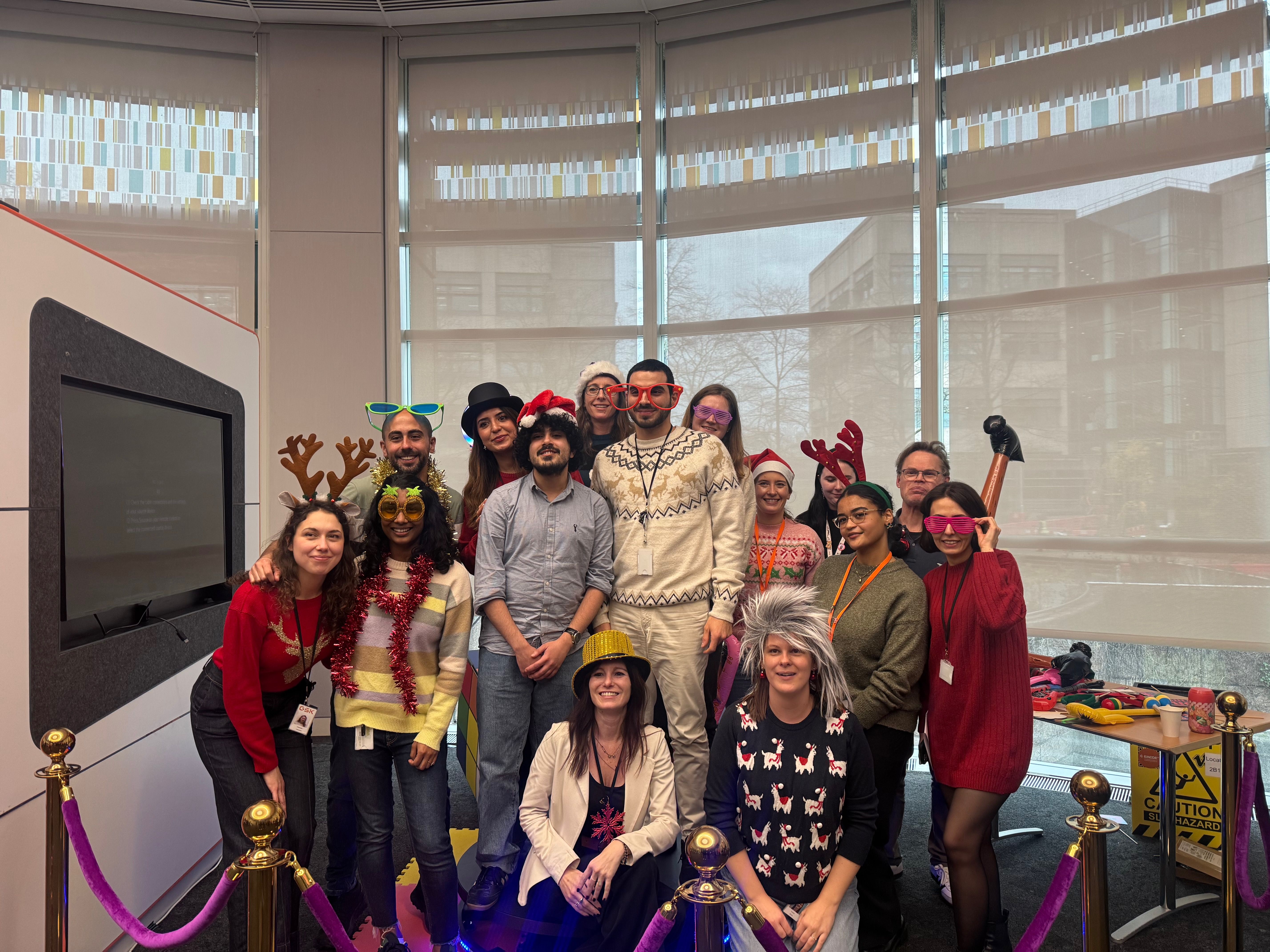 Group of colleagues wearing festive accessories including reindeer antlers, Santa hats and tinsel at a corporate Christmas party organised by Event Collection UK