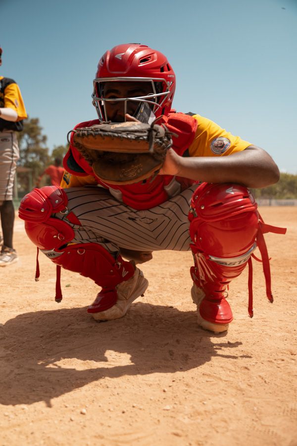 Young Dominican catcher in full gear ready behind home plate