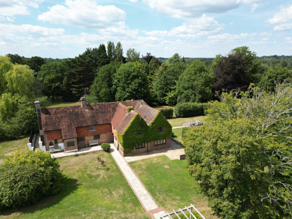 Aerial view of Sussex country house with ivy-covered walls and gardens