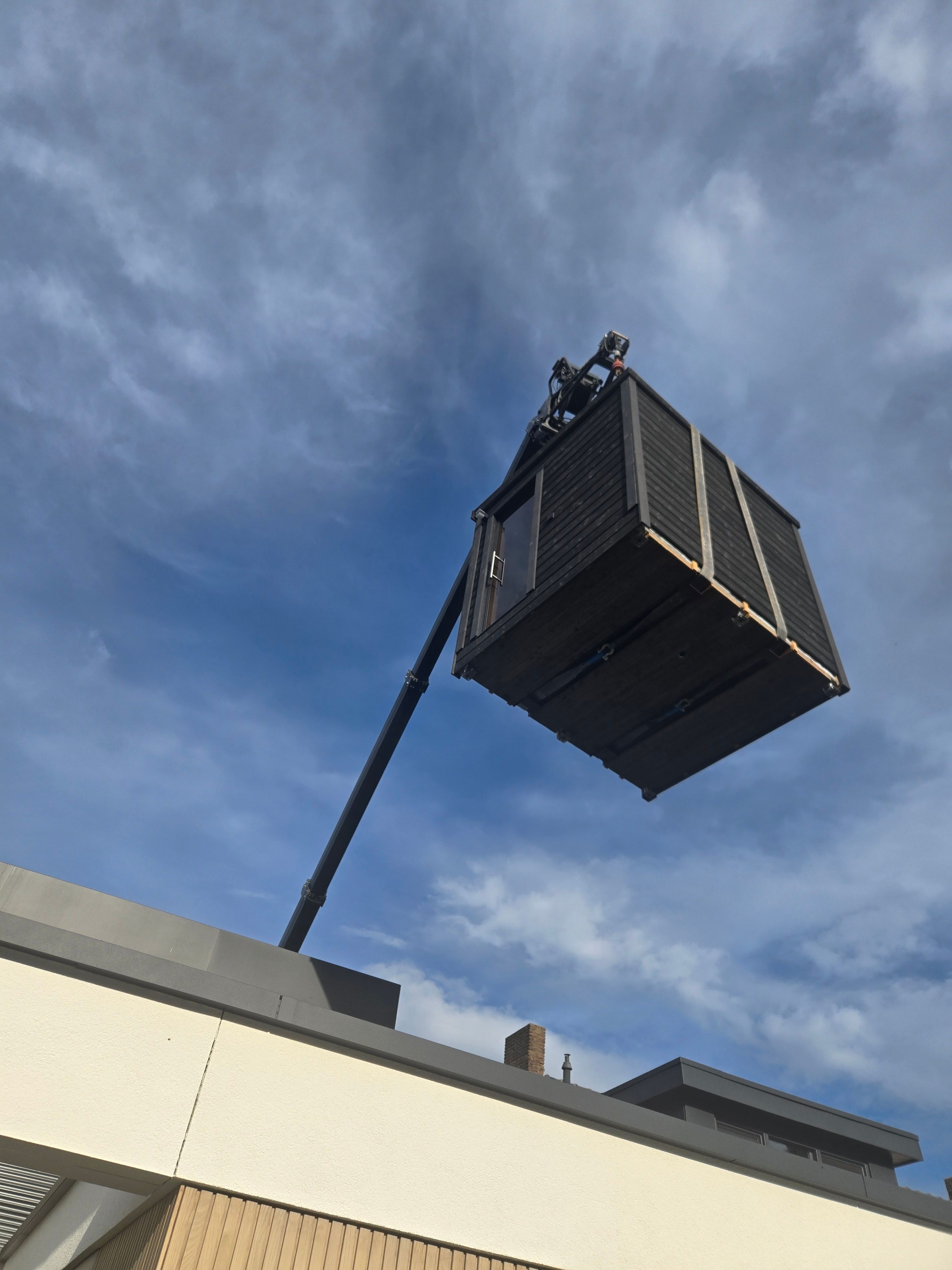 Crane lifting a unit over a building rooftop