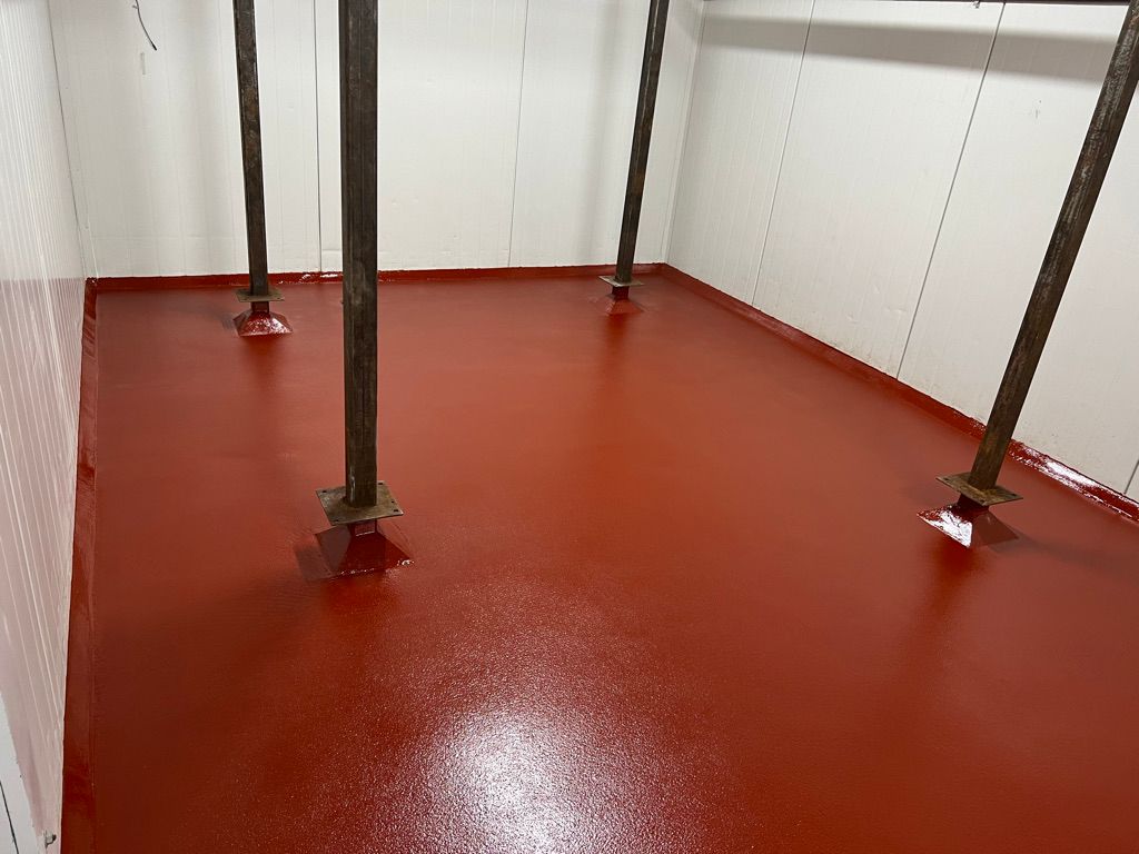 Food and beverage facility with freshly applied red epoxy floor and metal support columns