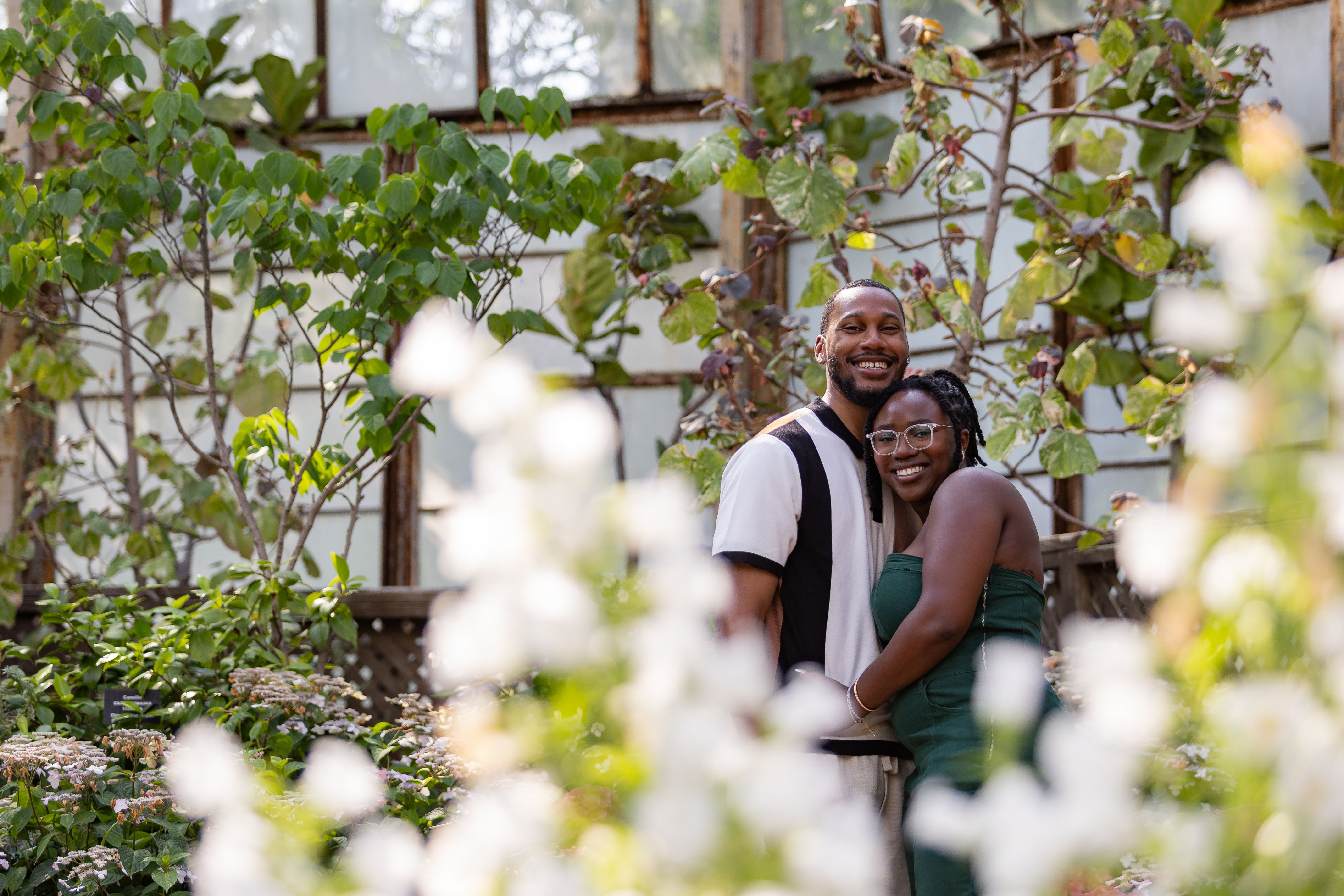 Couple in botanical garden seen through blooming flowers