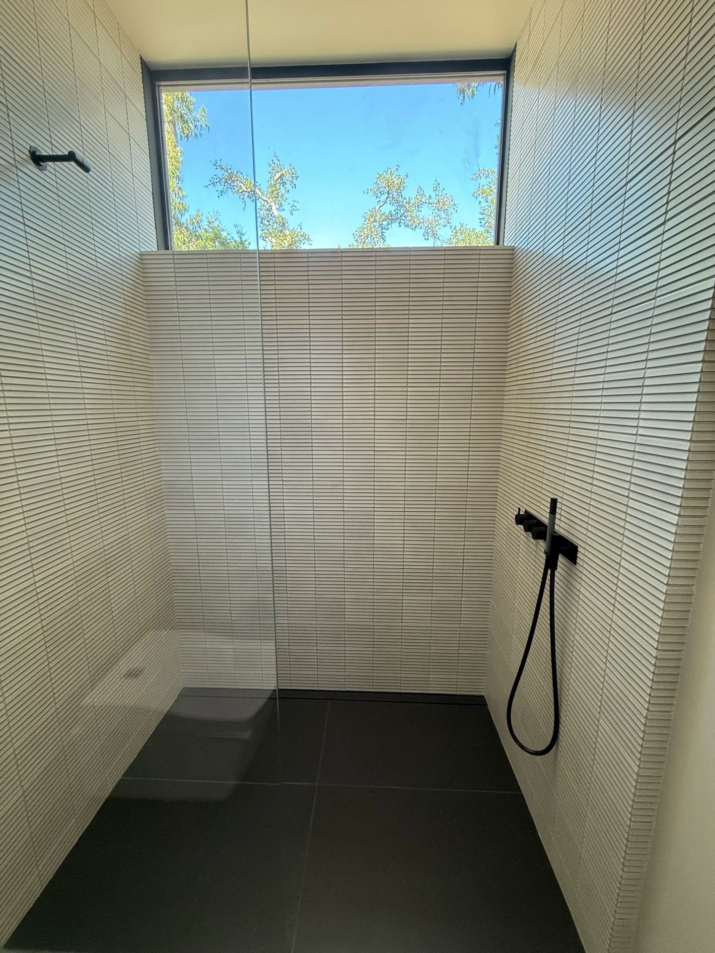 Modern shower with skylight view — luxury bathroom renovation by PGKB