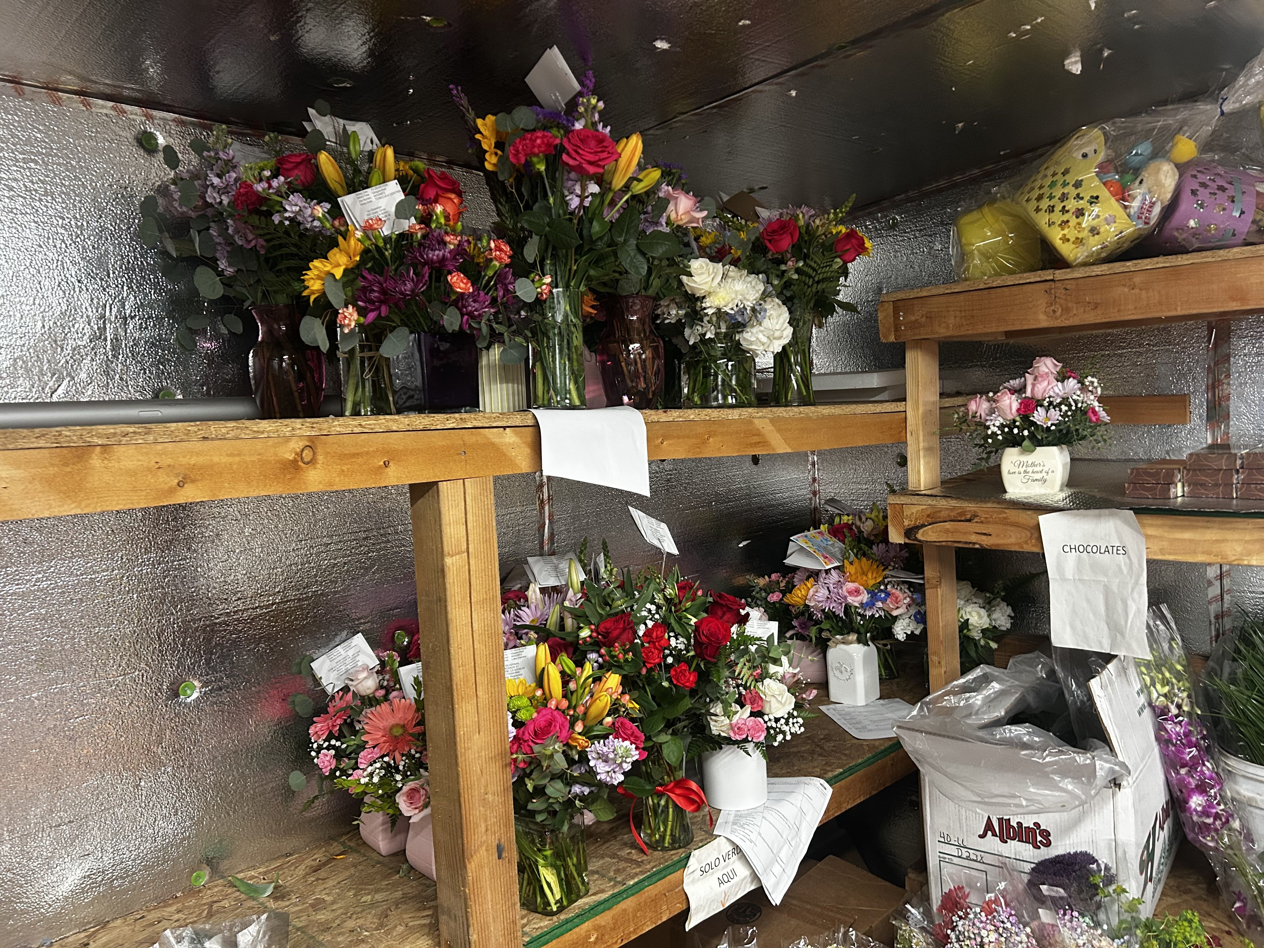 Indoor flower display with roses, lilies and daisies in glass vases