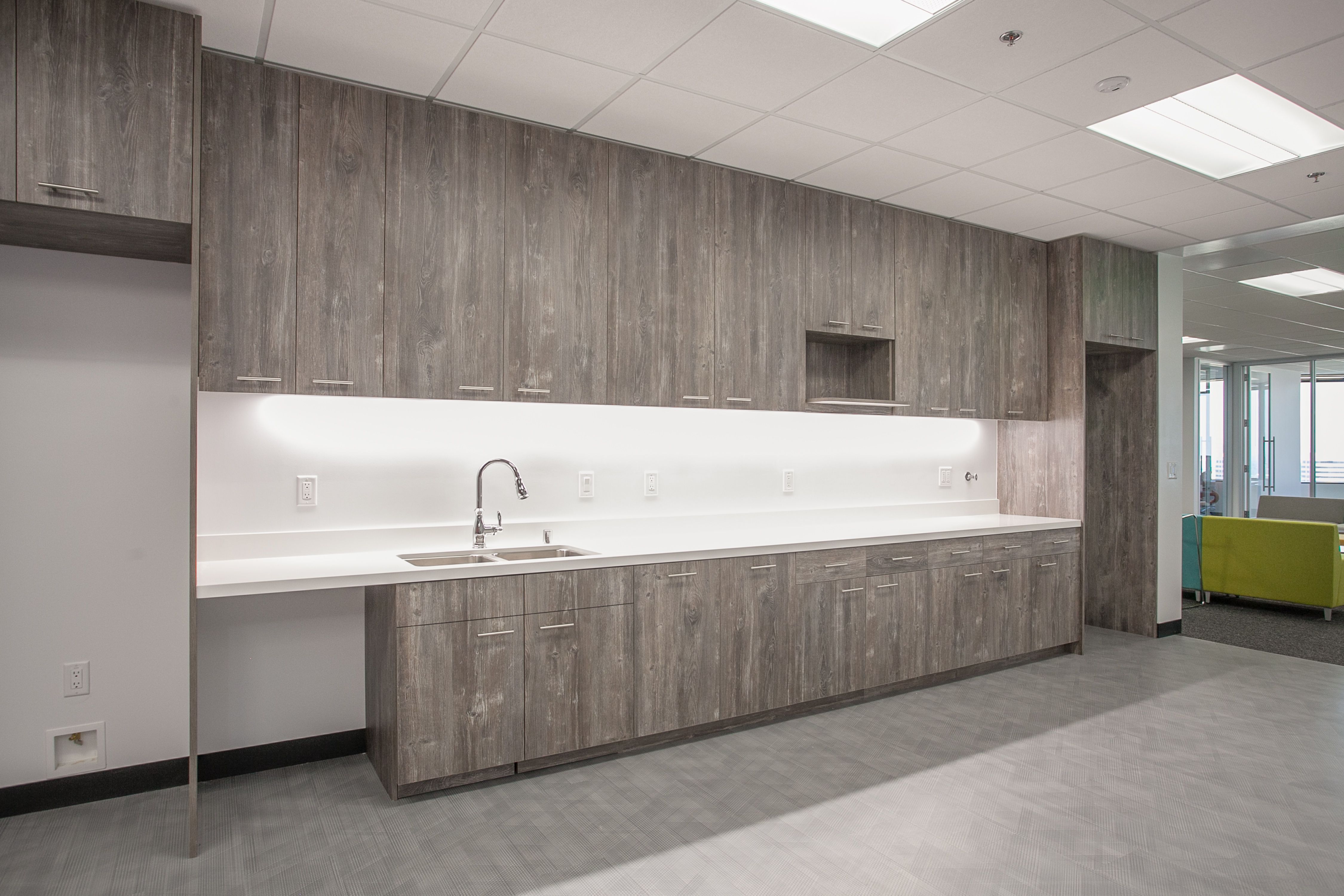 Commercial break room kitchen cabinetry with countertops and appliance integration in Woodland Hills CA