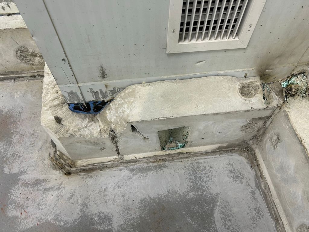 Worn wall-to-floor junction with deteriorated coating and corrosion near vent panel before restoration