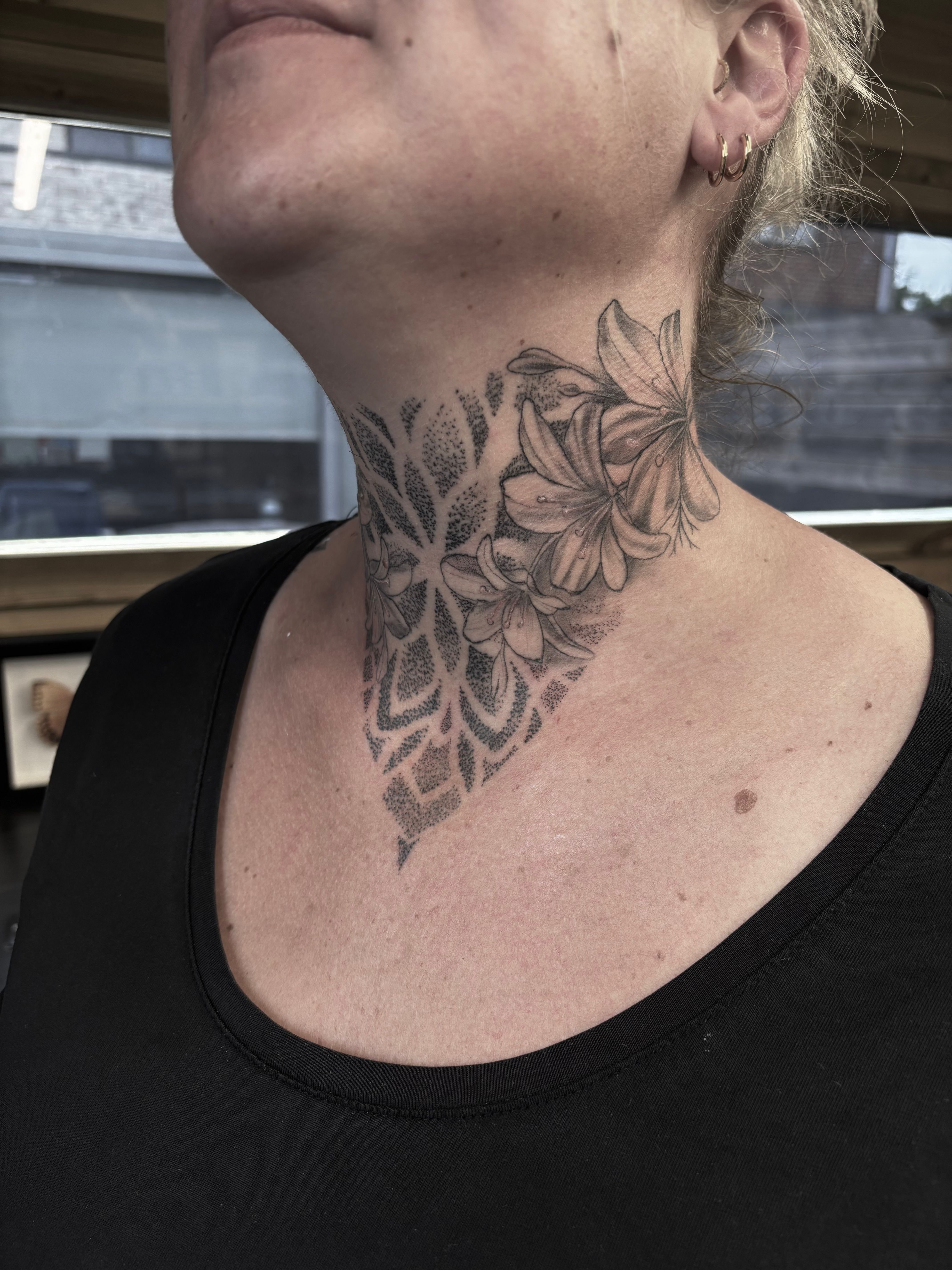 Bloemen en dotwork geometrie op de hals
