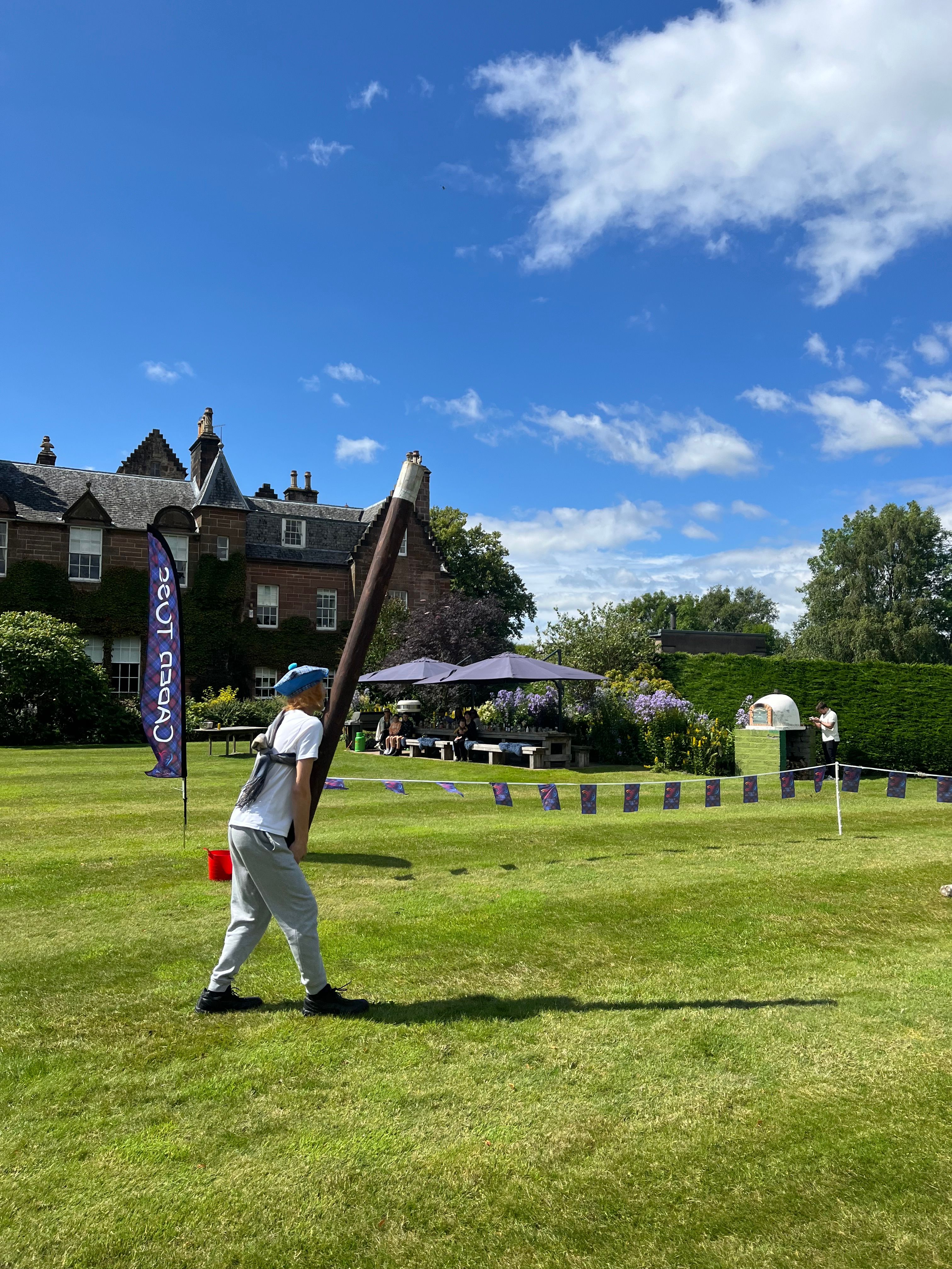 Highland Games corporate event — participants competing in caber toss and outdoor challenges at a scenic Scottish venue