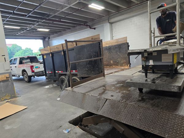 GoGo Junk Removal team at commercial loading dock removing old appliances including refrigerators and washing machines