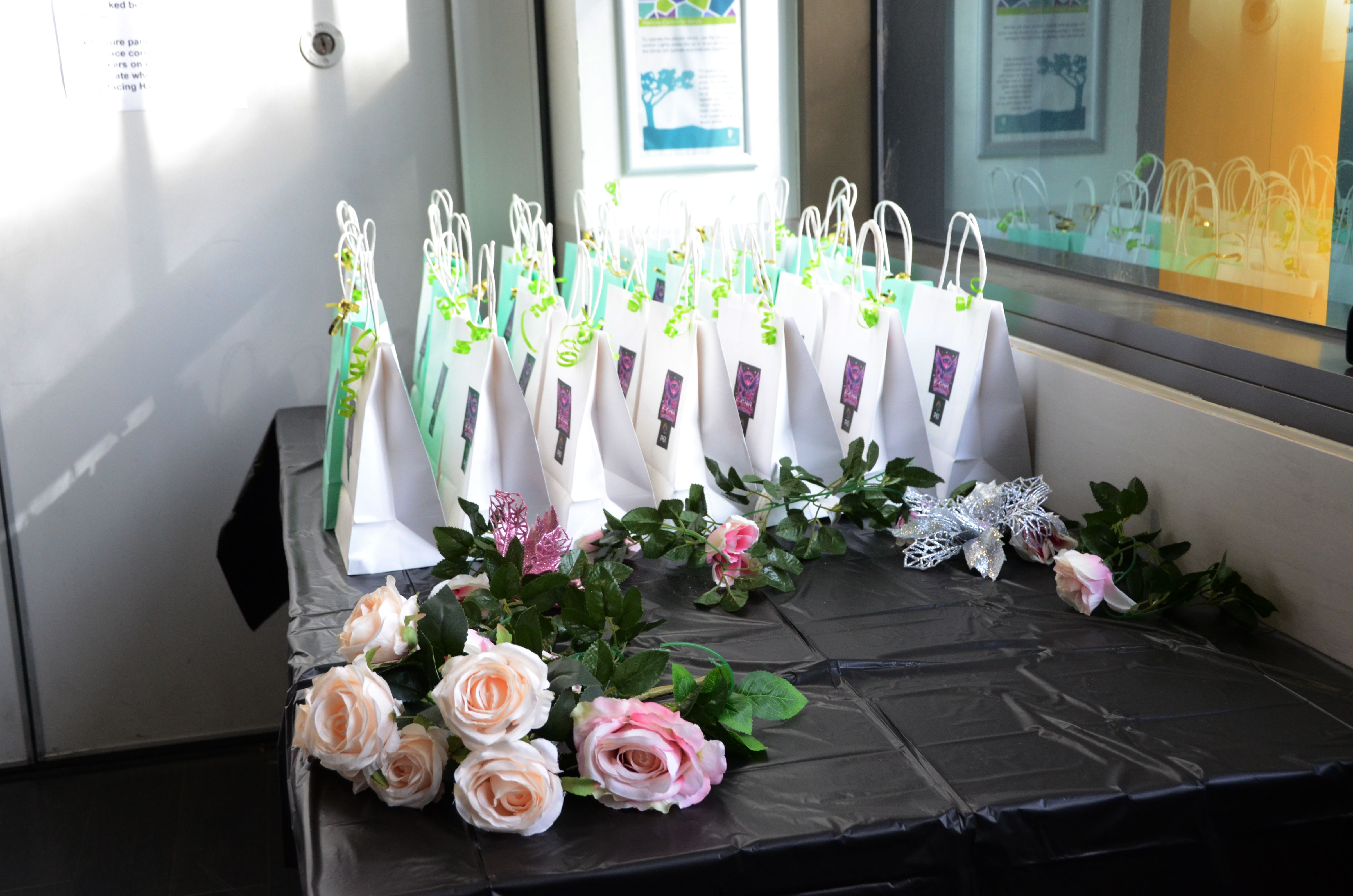 Gift bags and pink roses beautifully arranged for E-Girl Empowerment event attendees