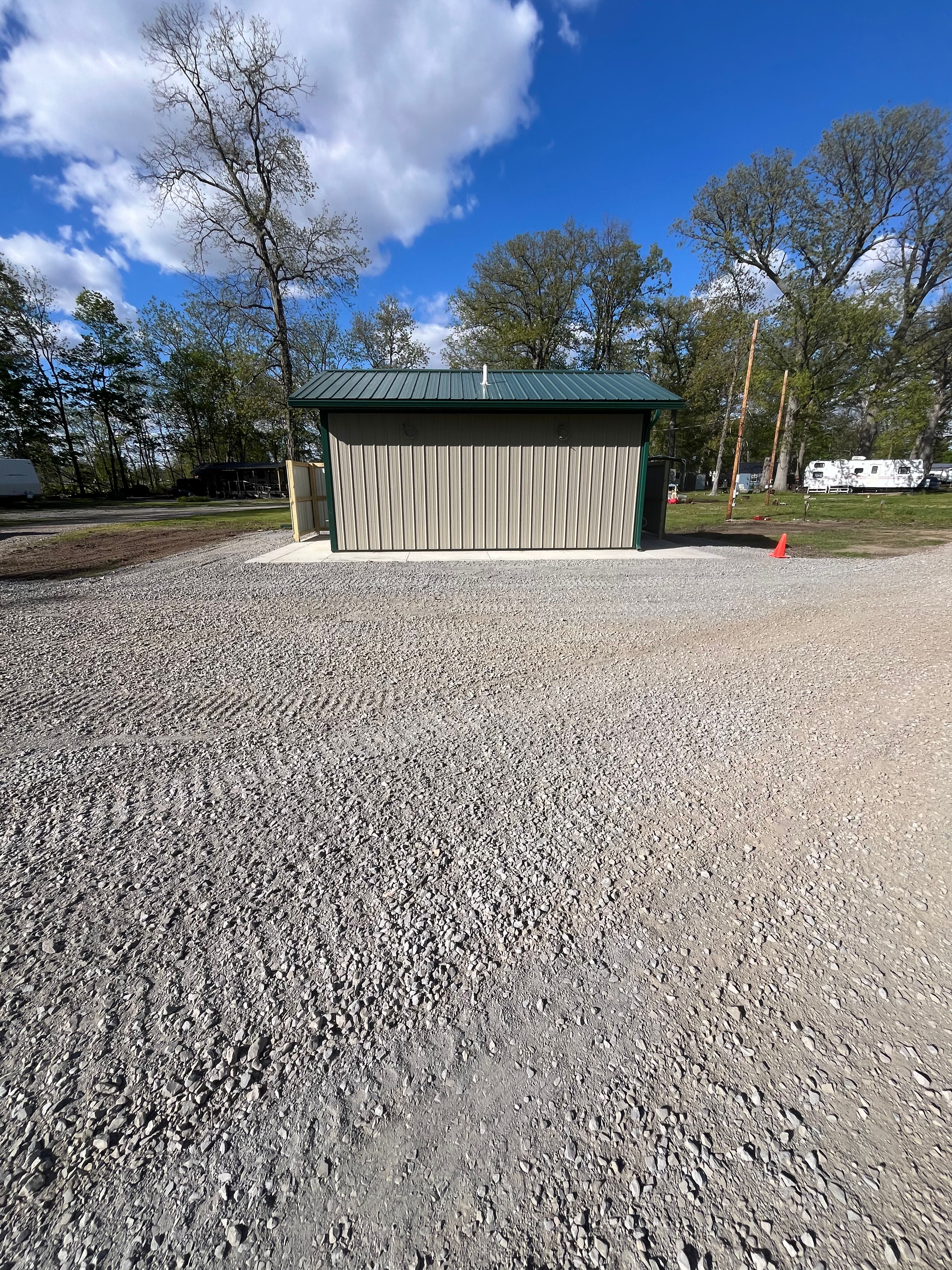 New campground building with beige siding and green roof at Welcome Woods
