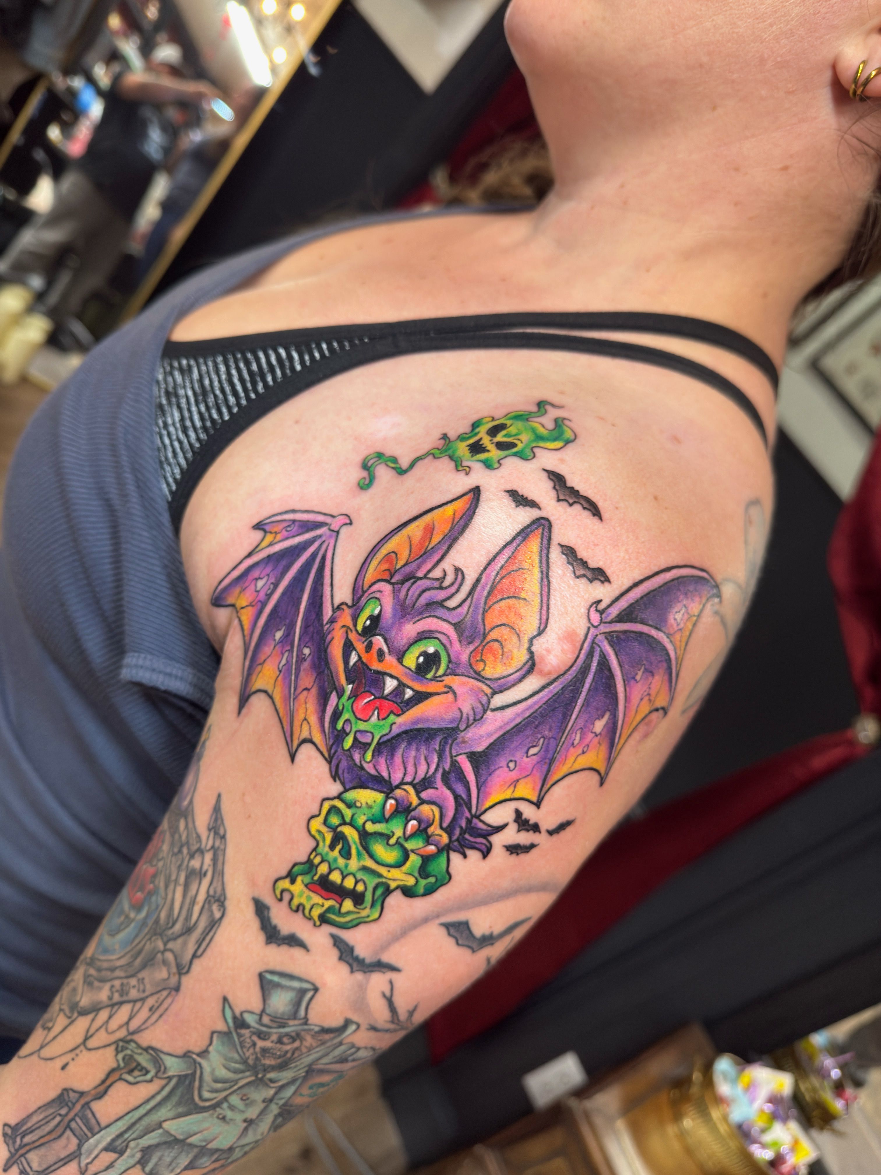 Color tattoo by Justin - purple bat holding a green skull