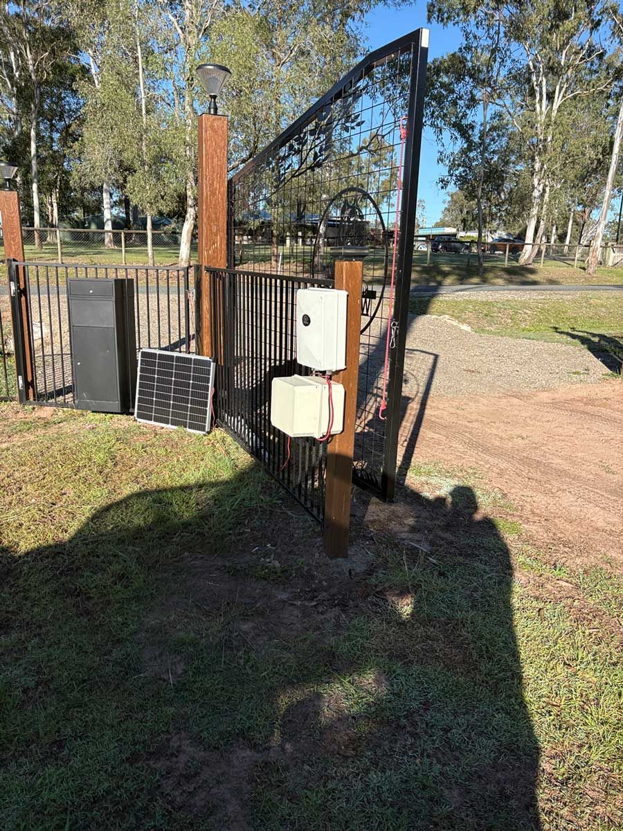 Solar powered gate motor setup on a rural property with solar panel on post