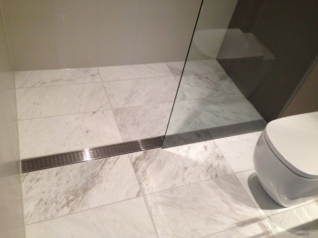 Heel guard floor grate installed in tiled bathroom