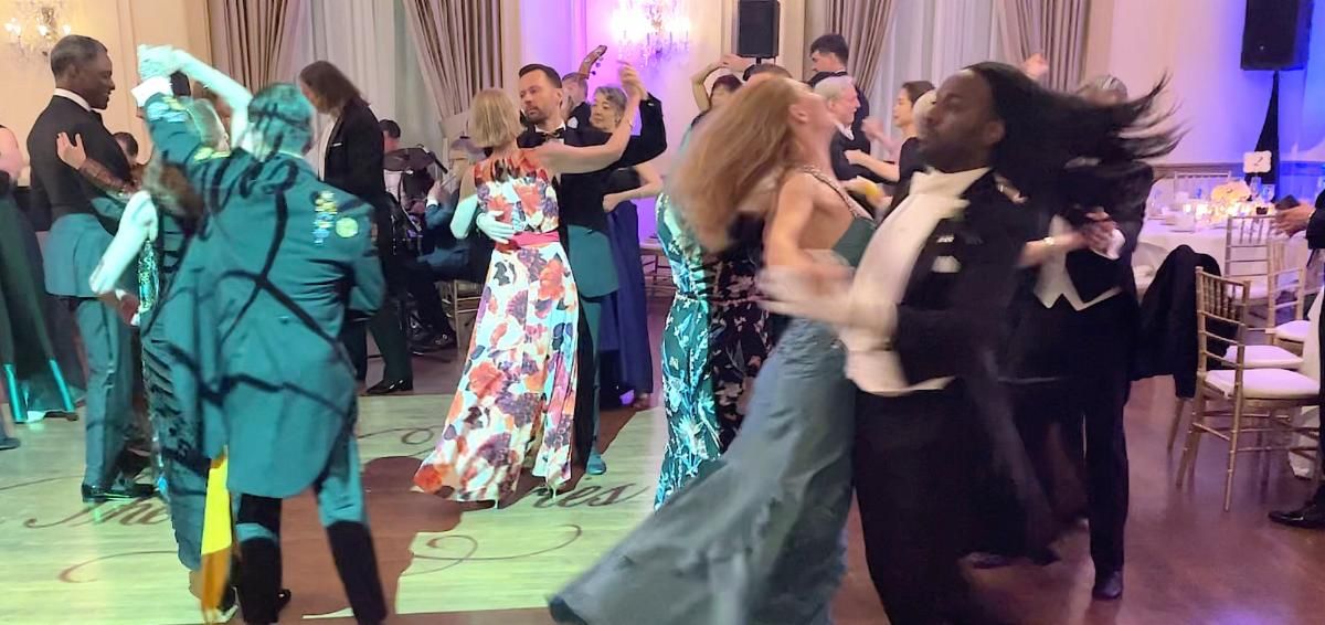 Multiple couples dancing in a ballroom β tuxedos and elegant dresses, chandeliers and purple lighting