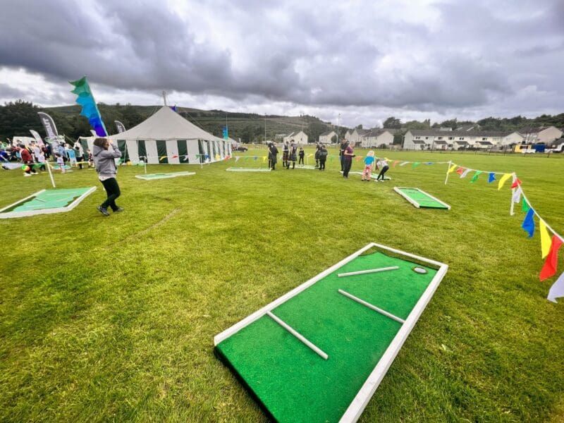 Children and adults playing mini golf at a corporate fun day event managed by Event Collection