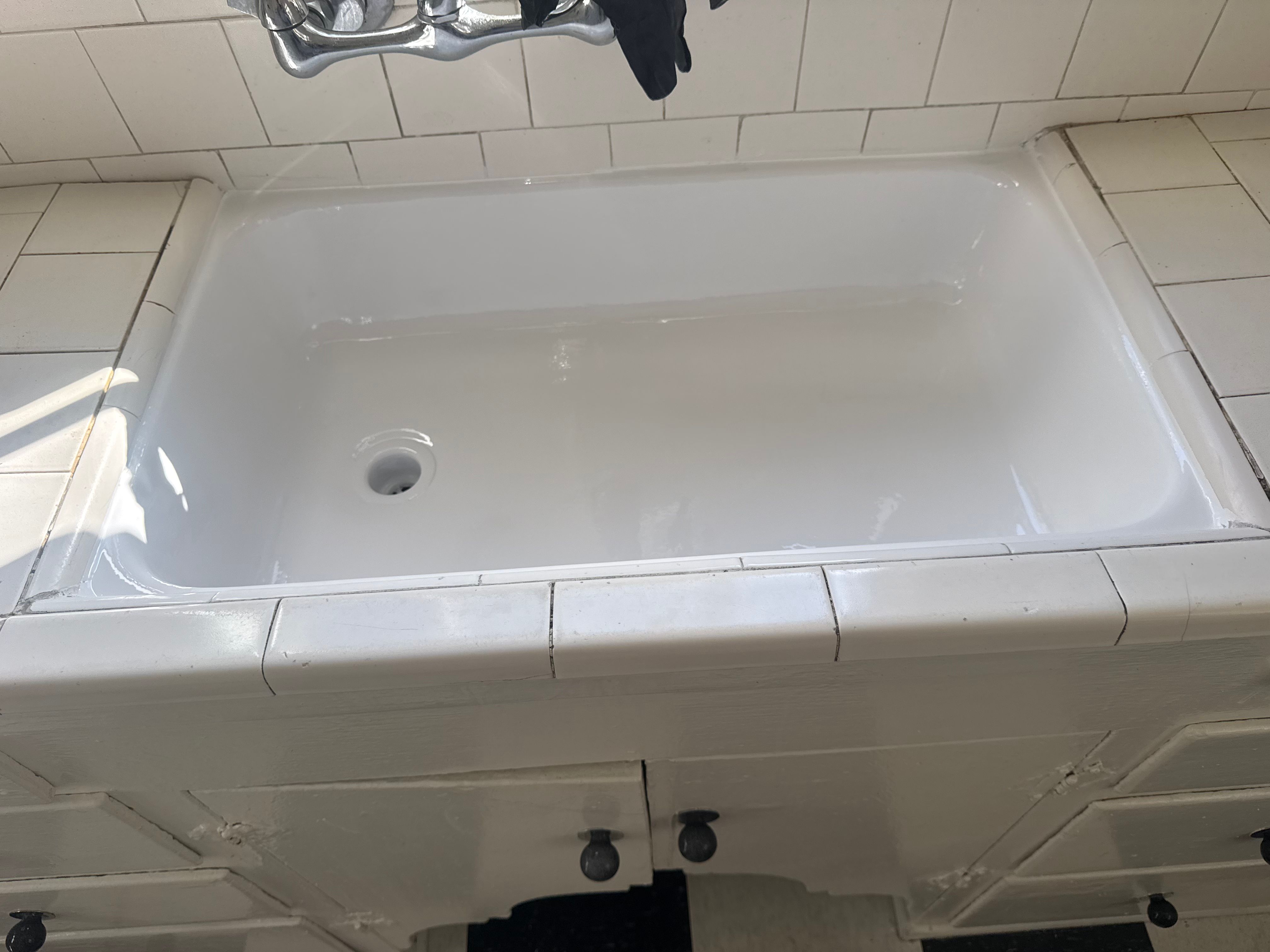 Bathtub before reglazing — original surface with faucet and cabinet by PMR Projects