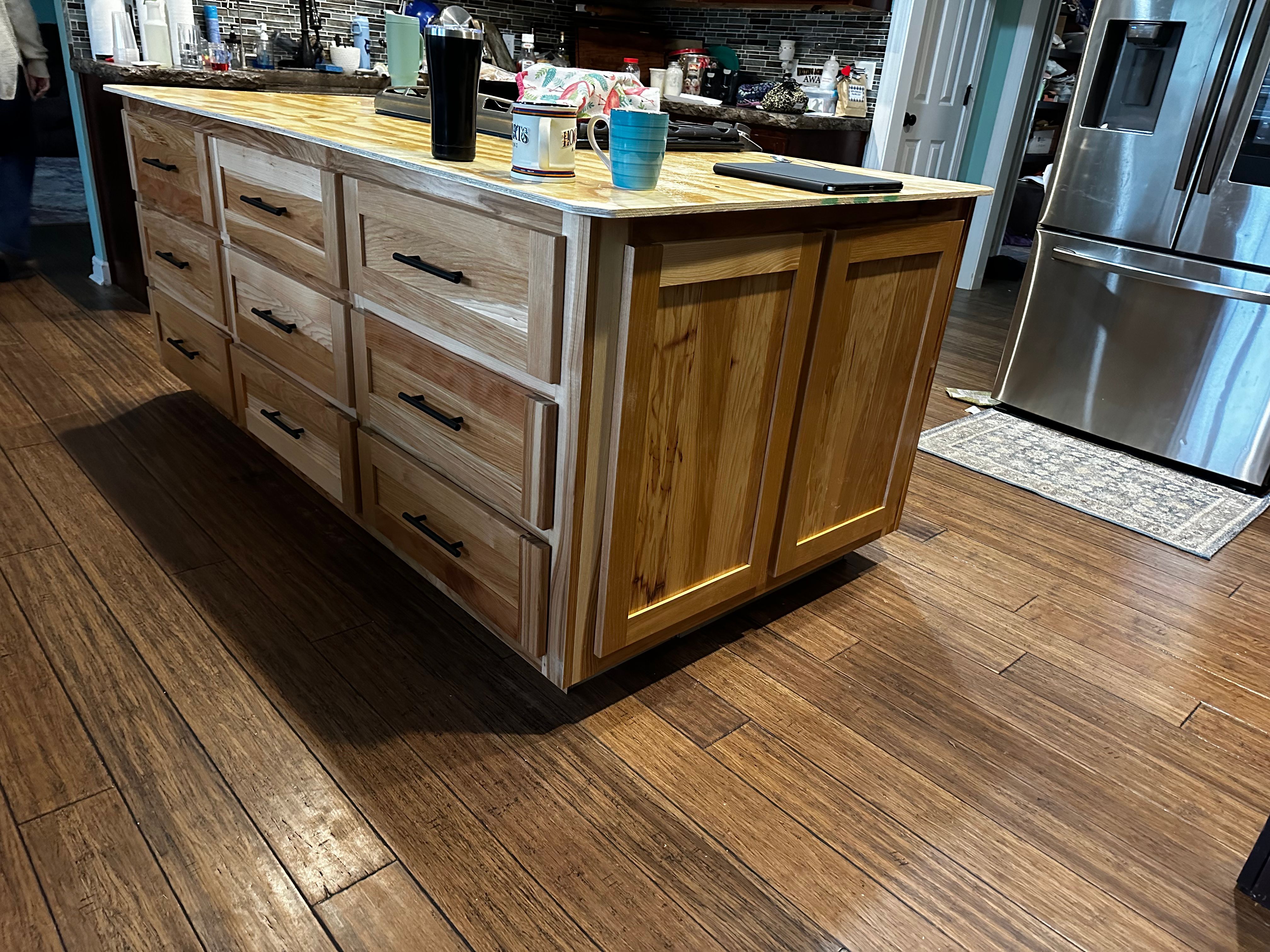 Wooden kitchen island with custom drawers and black handles
