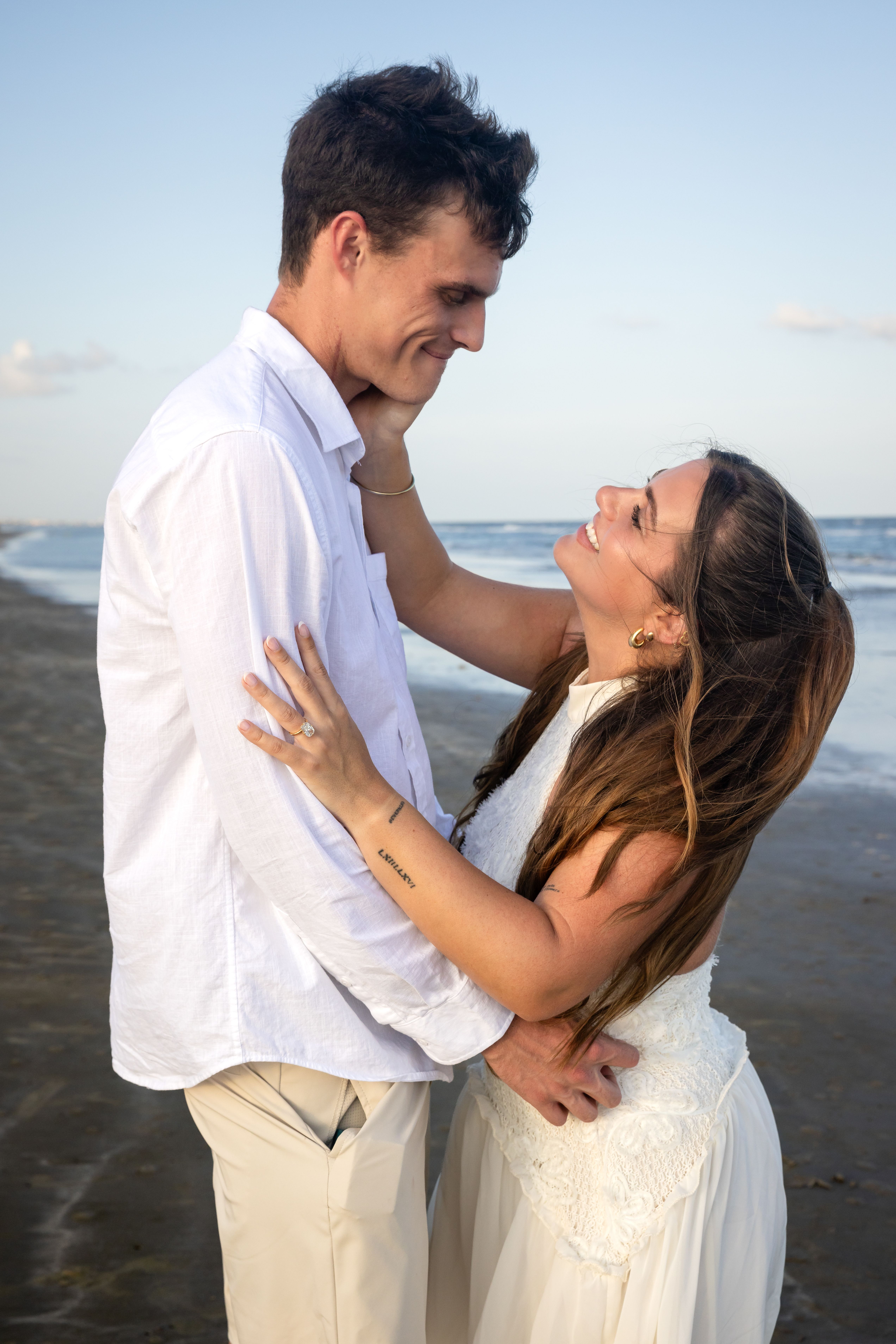Couple embracing on the beach — engagement session