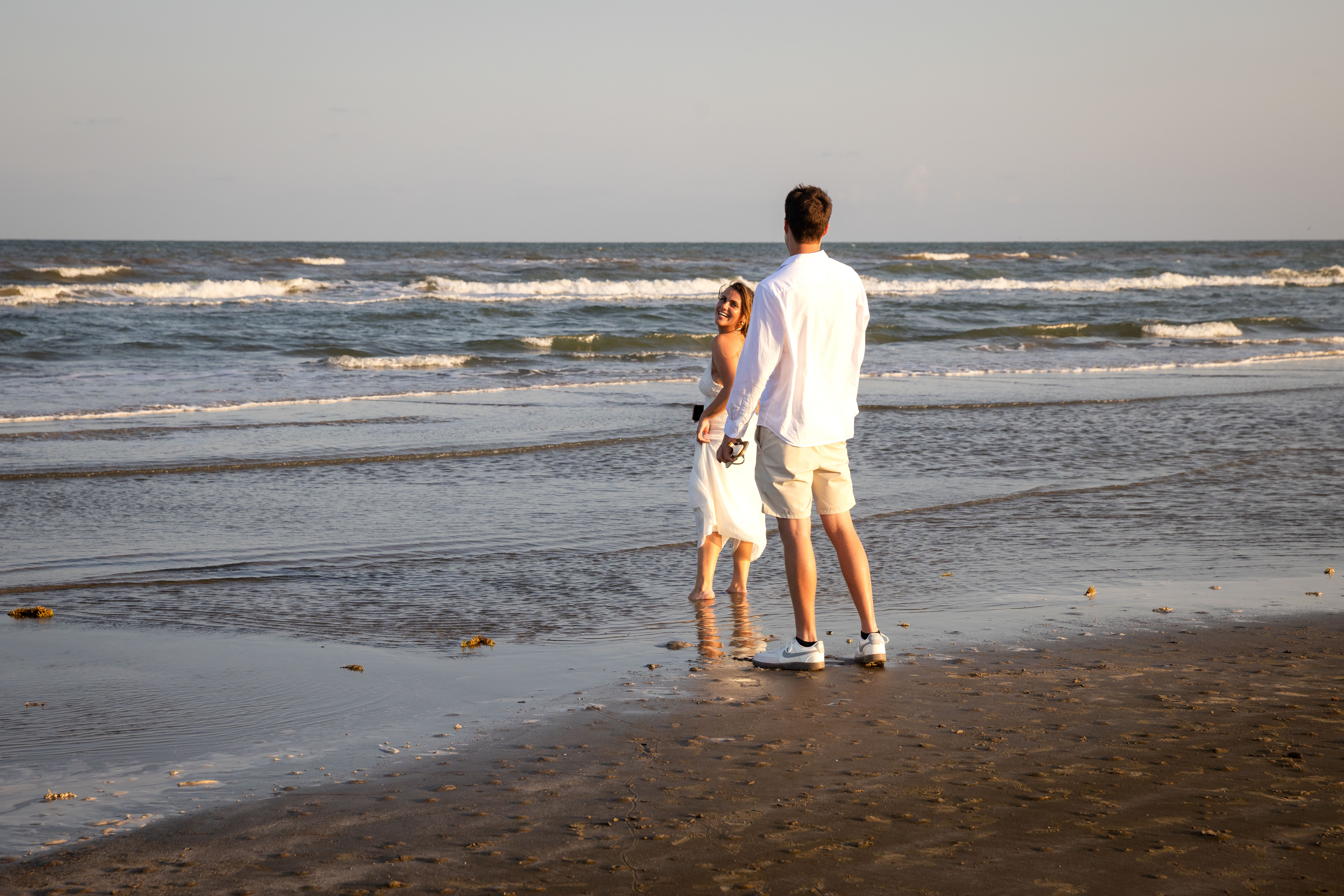 Young couple at the water's edge, beach engagement