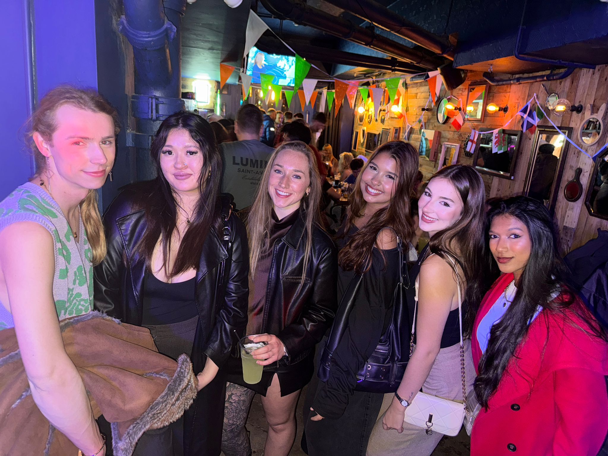 Group of international friends enjoying a guided Glasgow pub crawl with Ebrius on a Saturday night