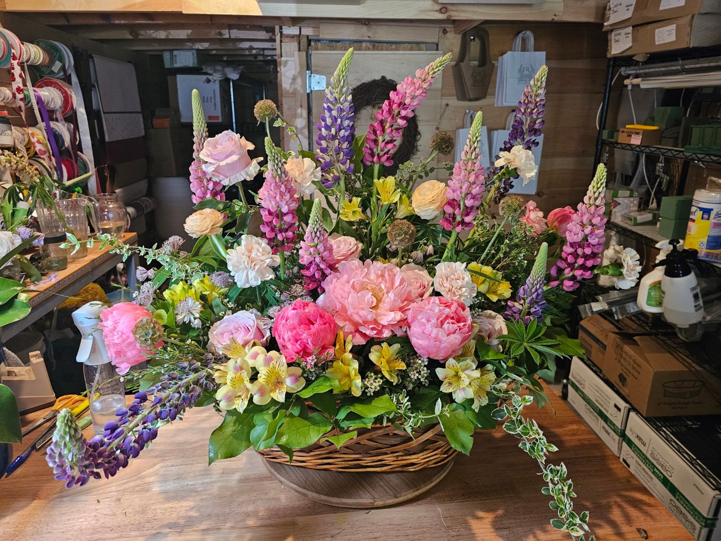 Lush basket arrangement with peonies, lupines, and alstroemeria