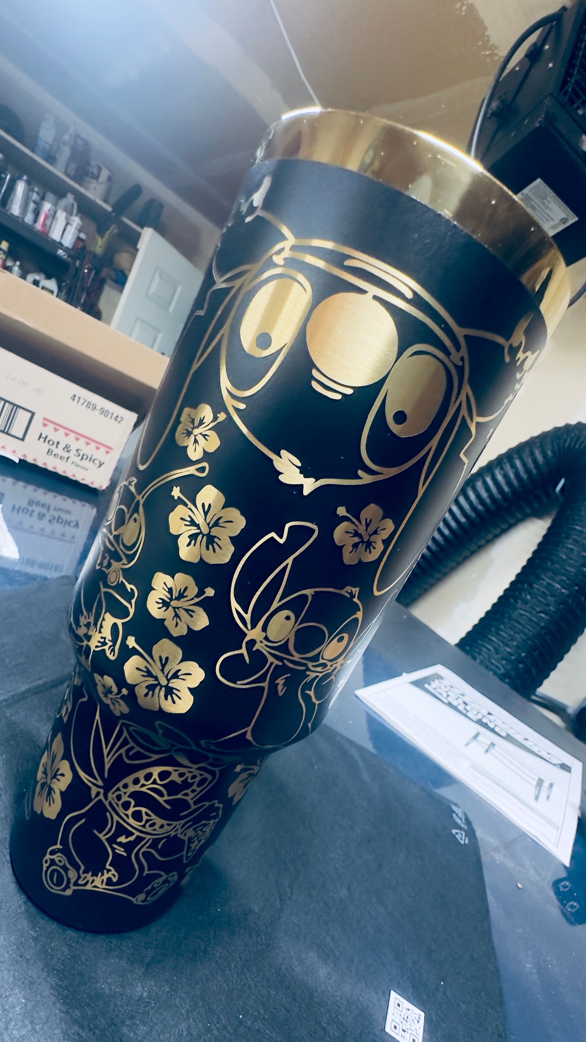 Black tumbler with gold laser-engraved artwork