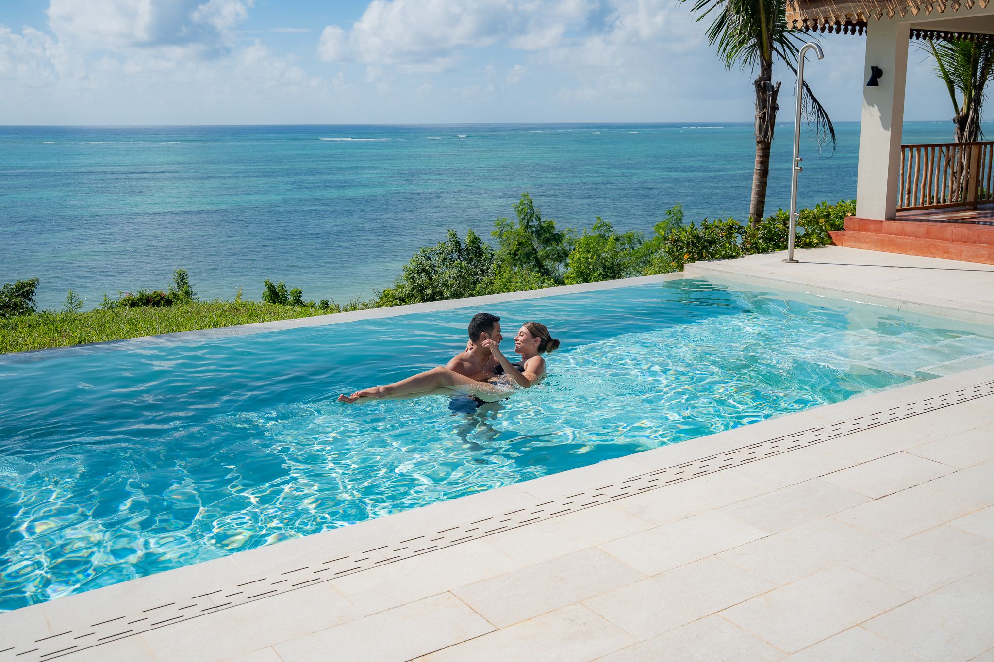 Couple in infinity pool with ocean view — spontaneous Zanzibar photoshoot