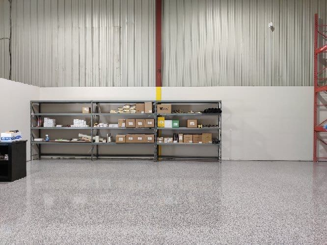 Retail back room with polished speckled floor, metal shelving unit with boxed inventory and red structural column