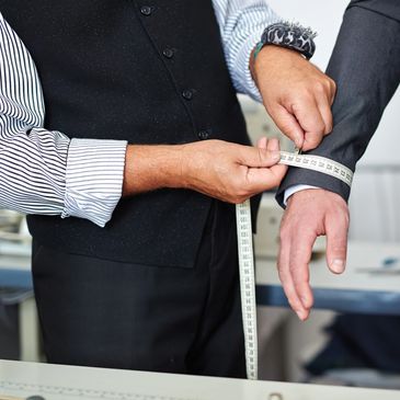 Tailor measuring a client for a custom suit in Houston — BLU Fine Menswear bespoke process