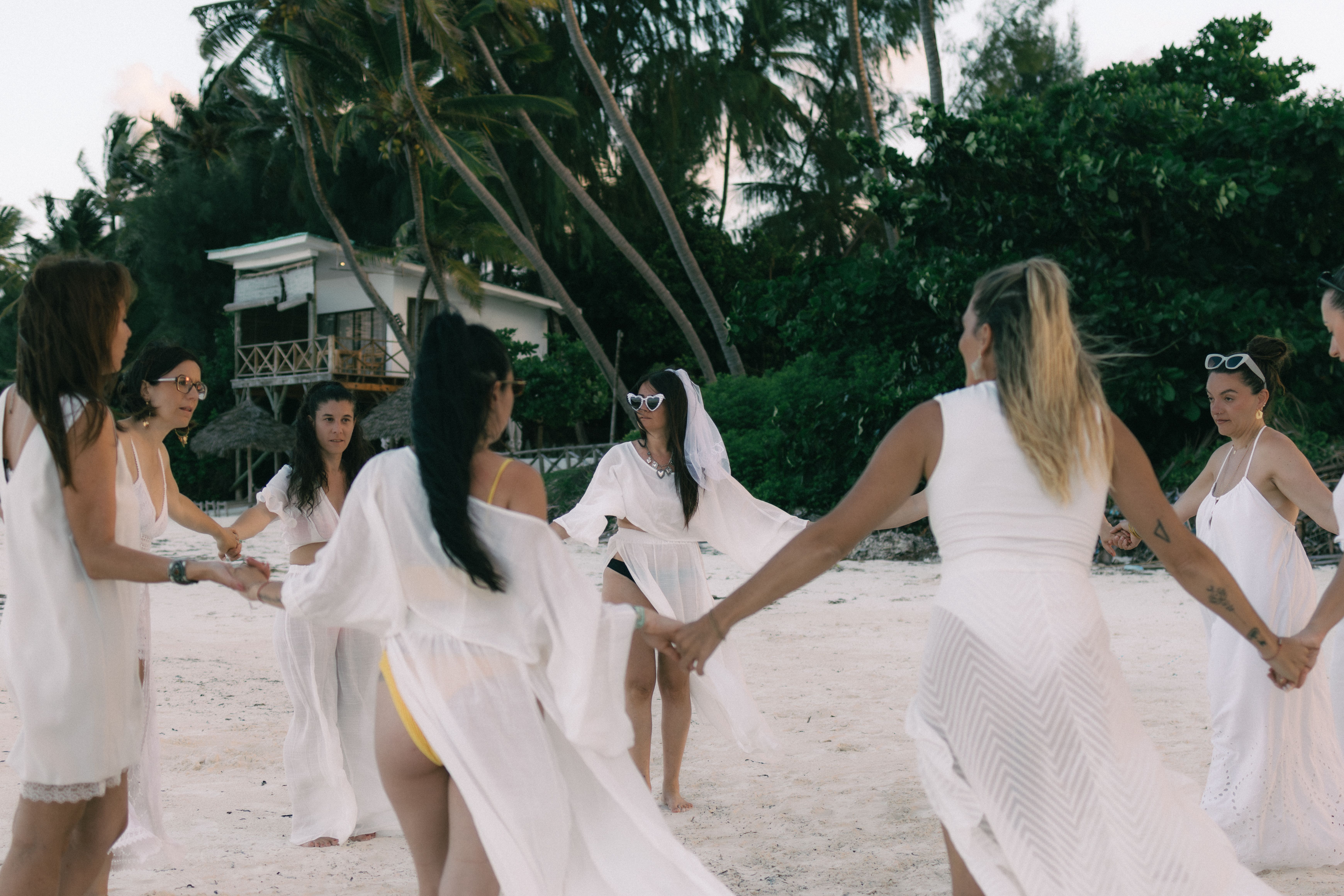 Group of women in white on beach — bachelorette photoshoot