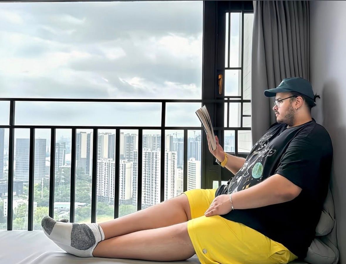 Patrick reading by a window