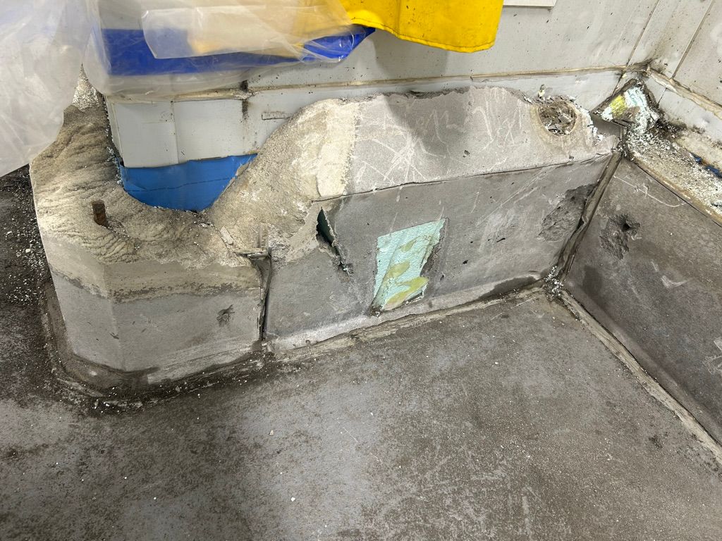 Damaged concrete corner with cracks, chipped sections and exposed substrate before polymer repair
