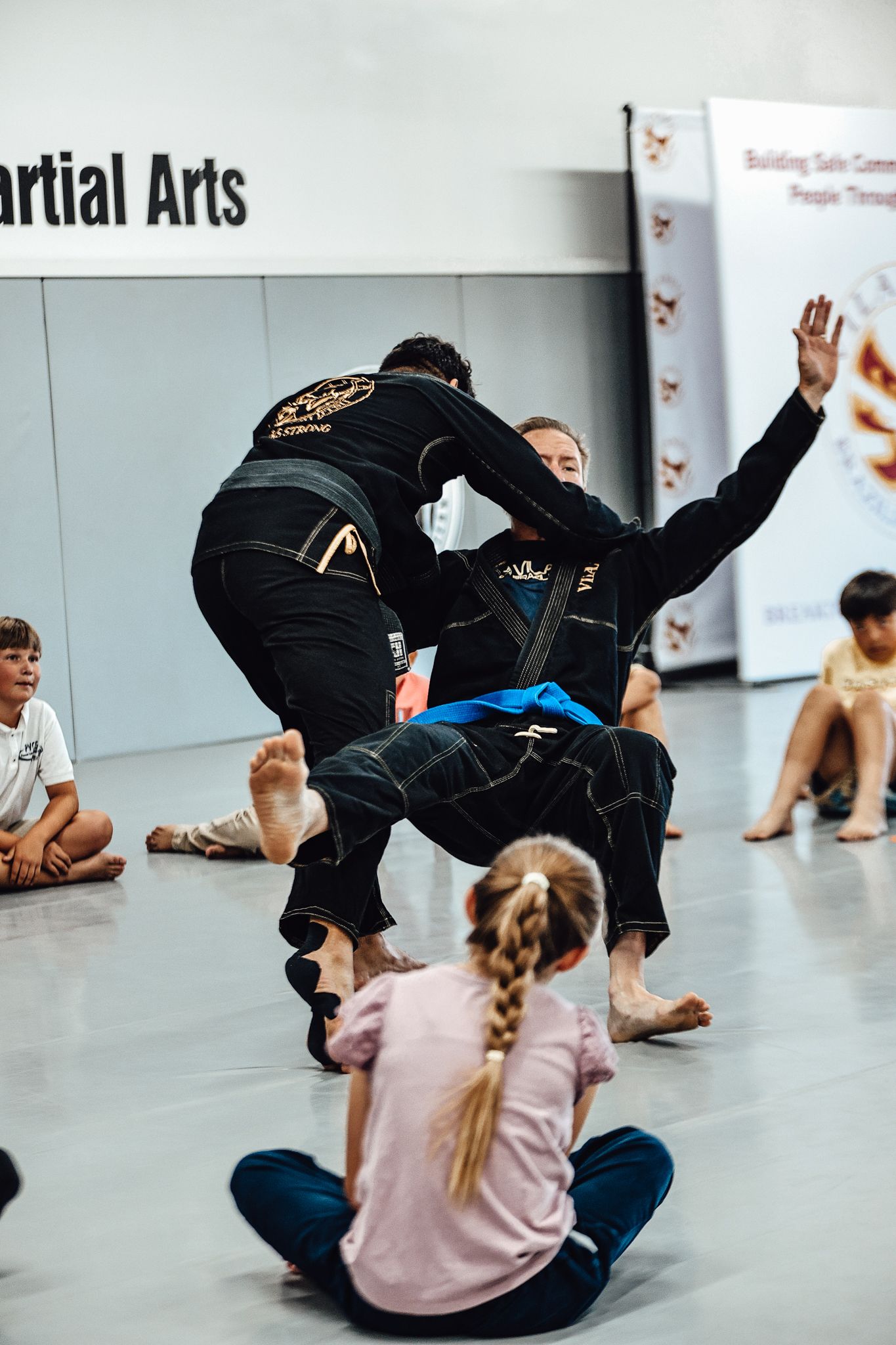 Instructors demonstrating throwing technique while children observe