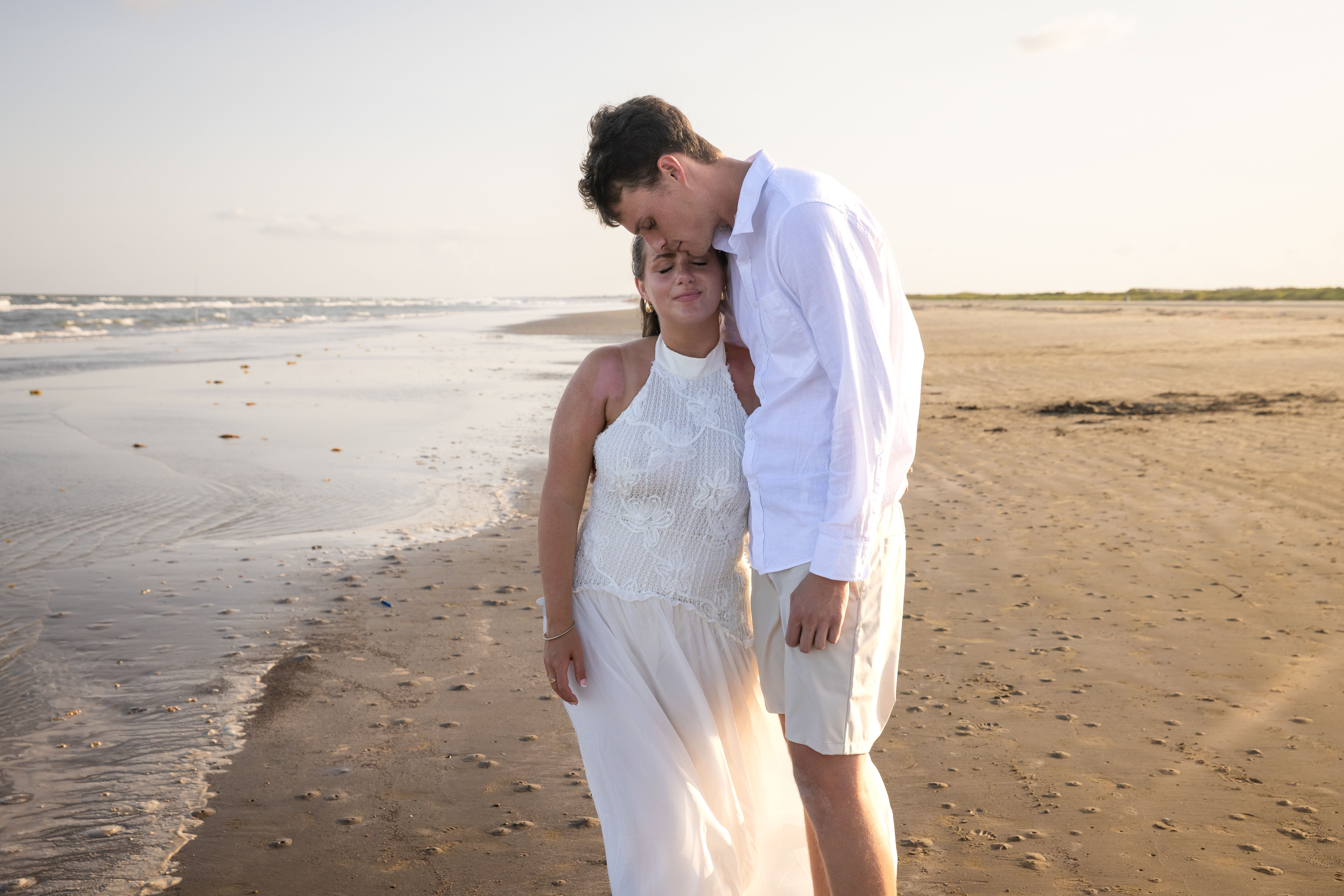 Couple with heads together on a sunny beach