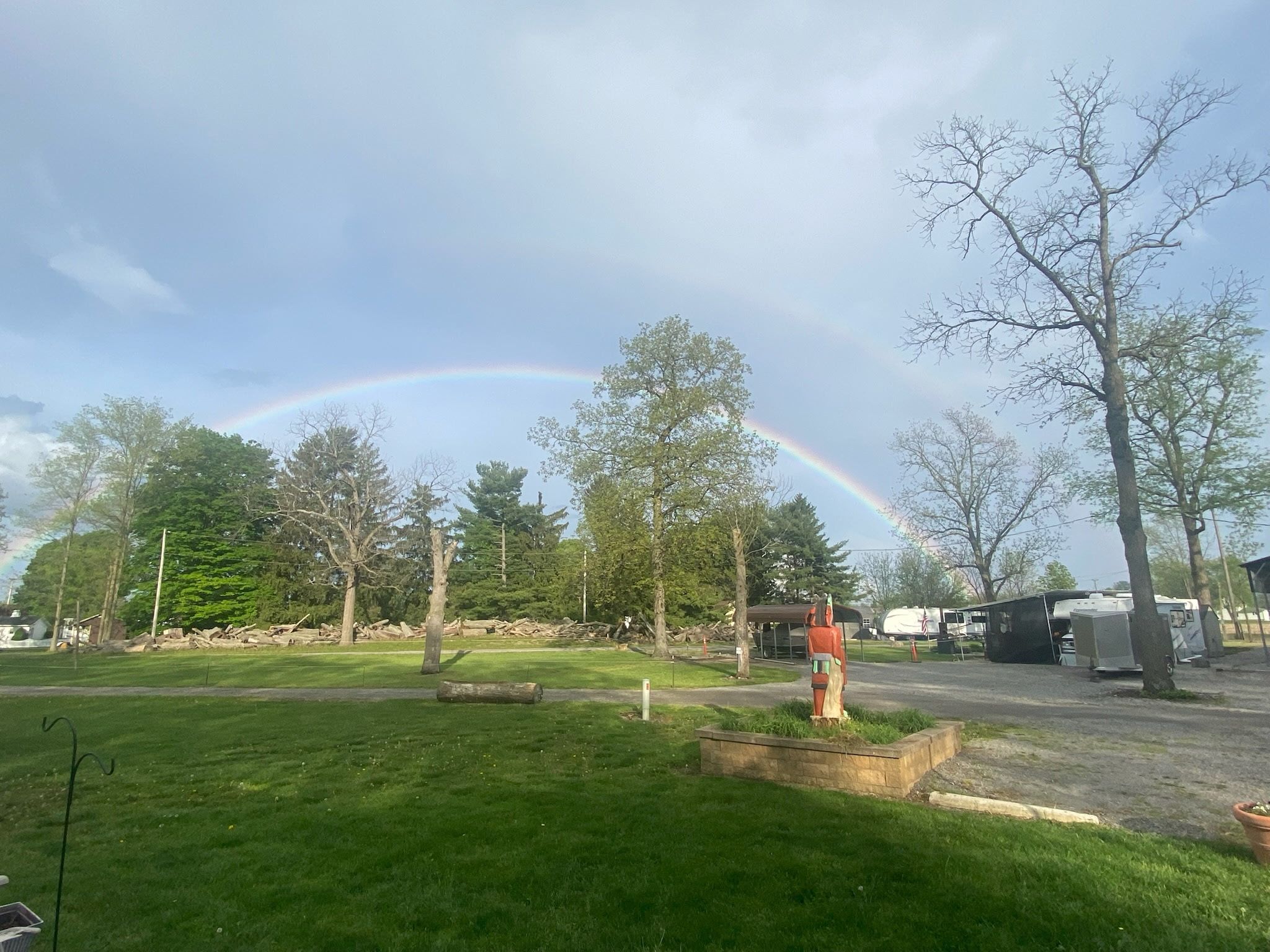 Double rainbow over Welcome Woods campground with trees and RVs
