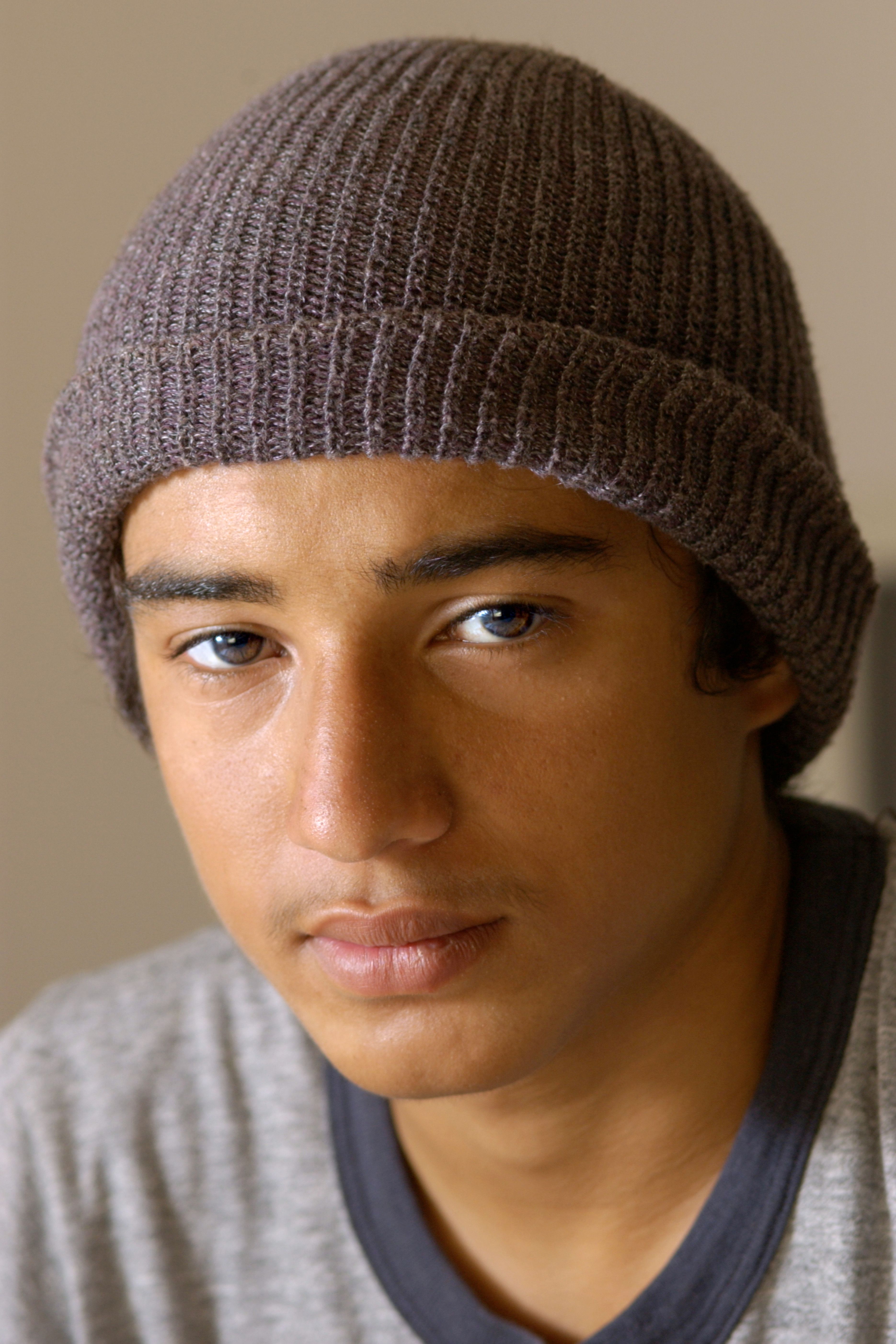 Young person in a beanie looking thoughtful
