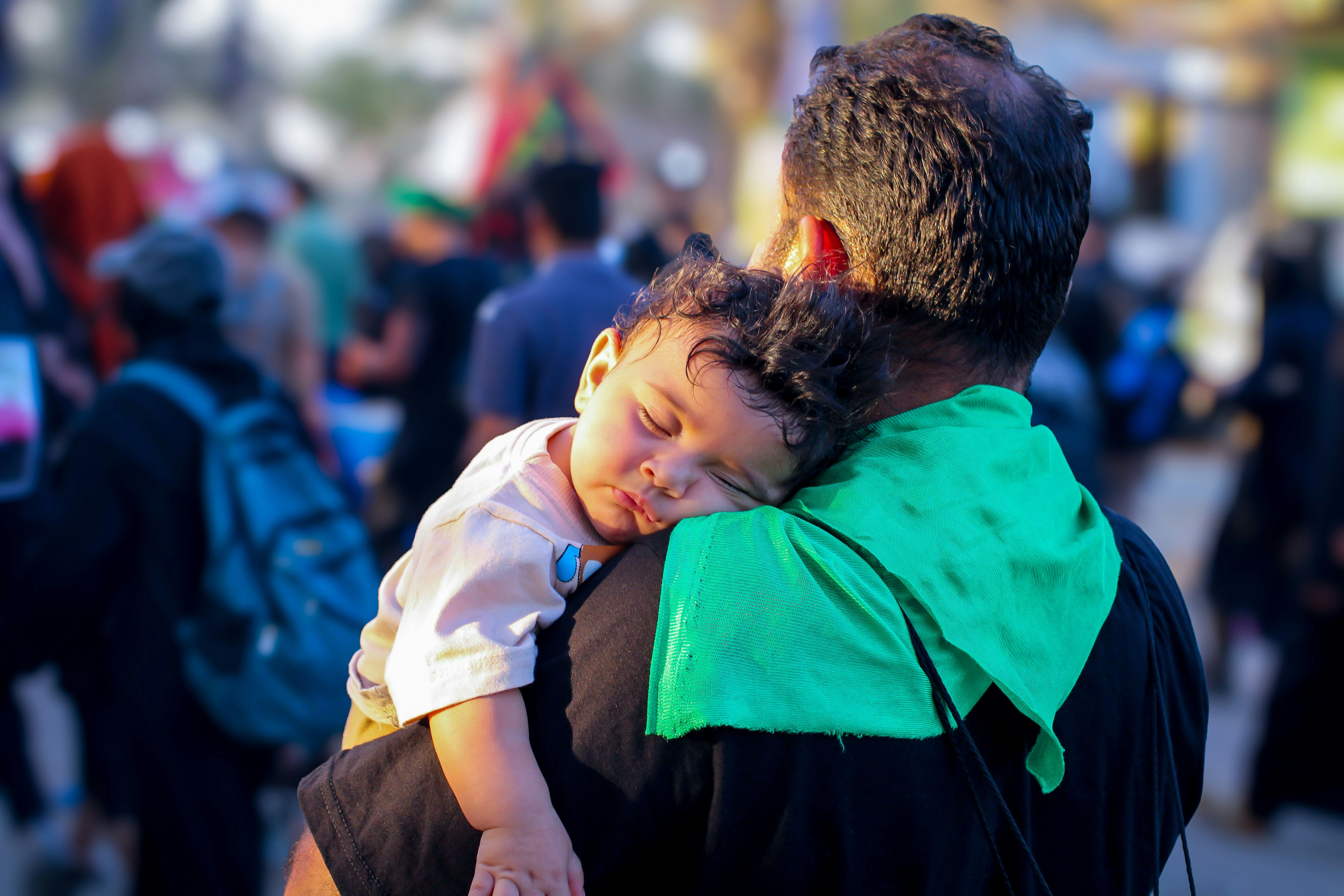 Father holding his sleeping baby on his shoulder