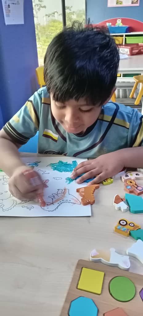 Boy coloring a dinosaur
