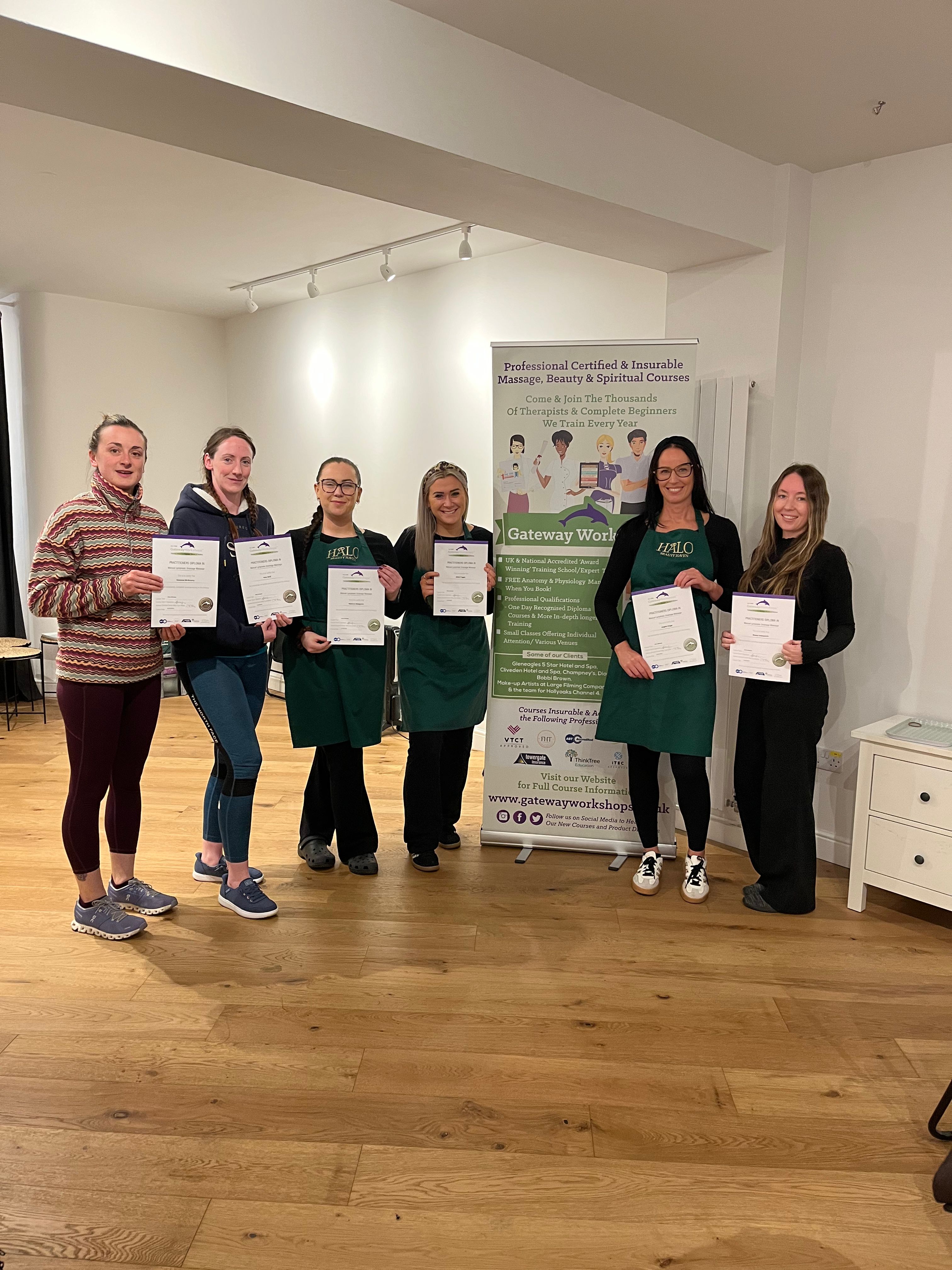 Gateway Workshops graduates holding certificates after completing massage therapy training with Amy Johnson