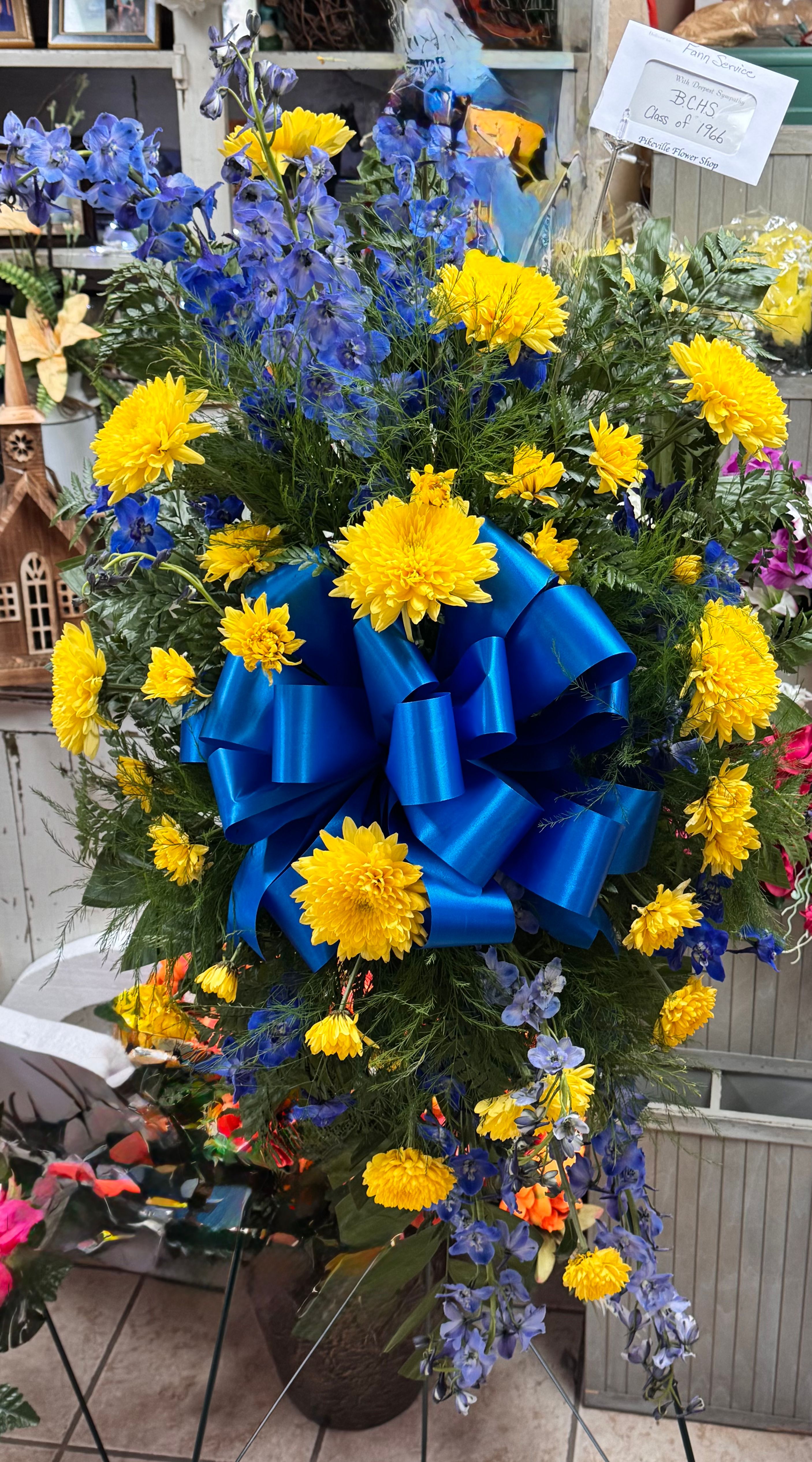 Yellow and blue standing spray with blue ribbon