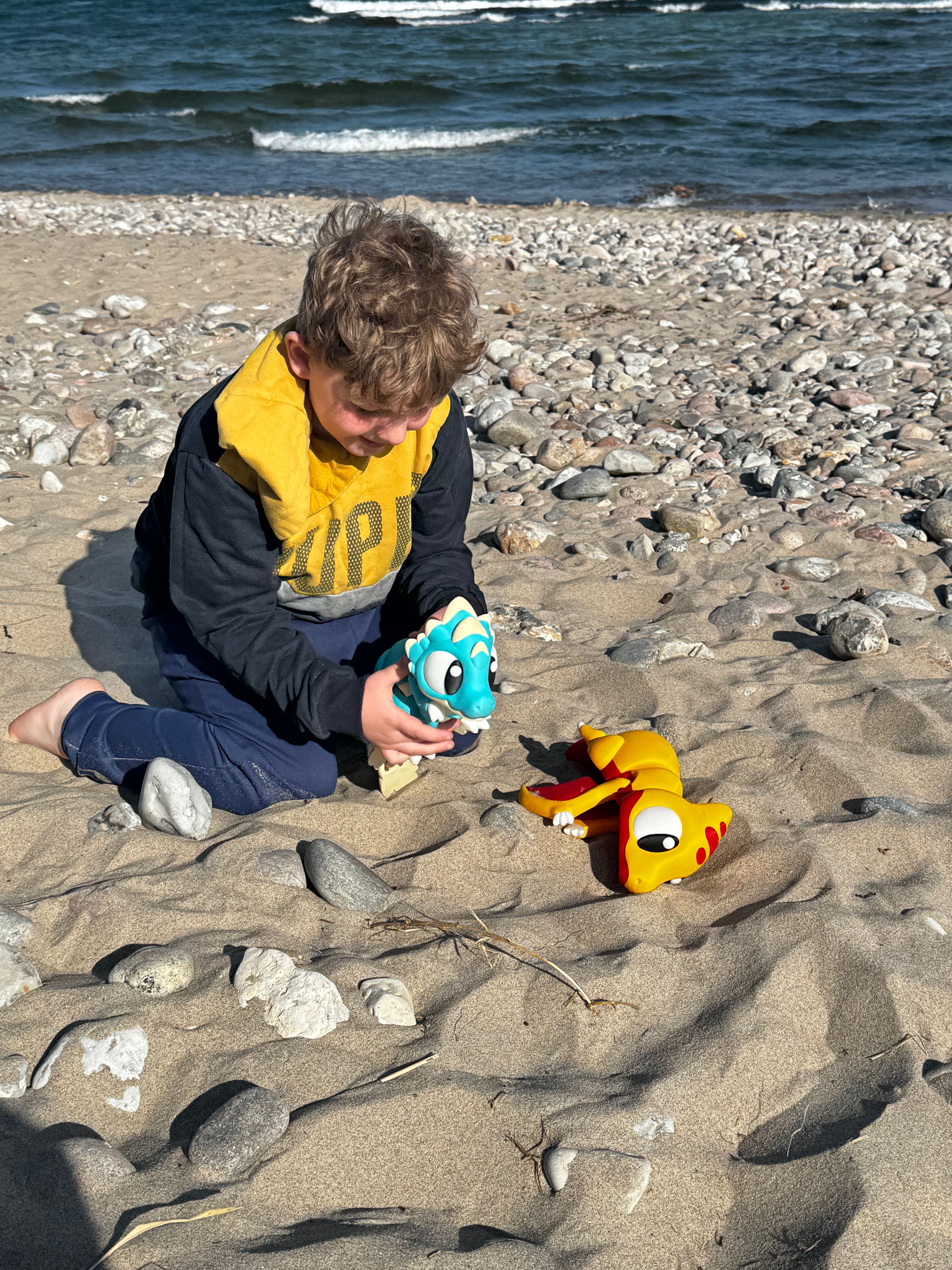 Child playing with flexi dinosaurs at the beach