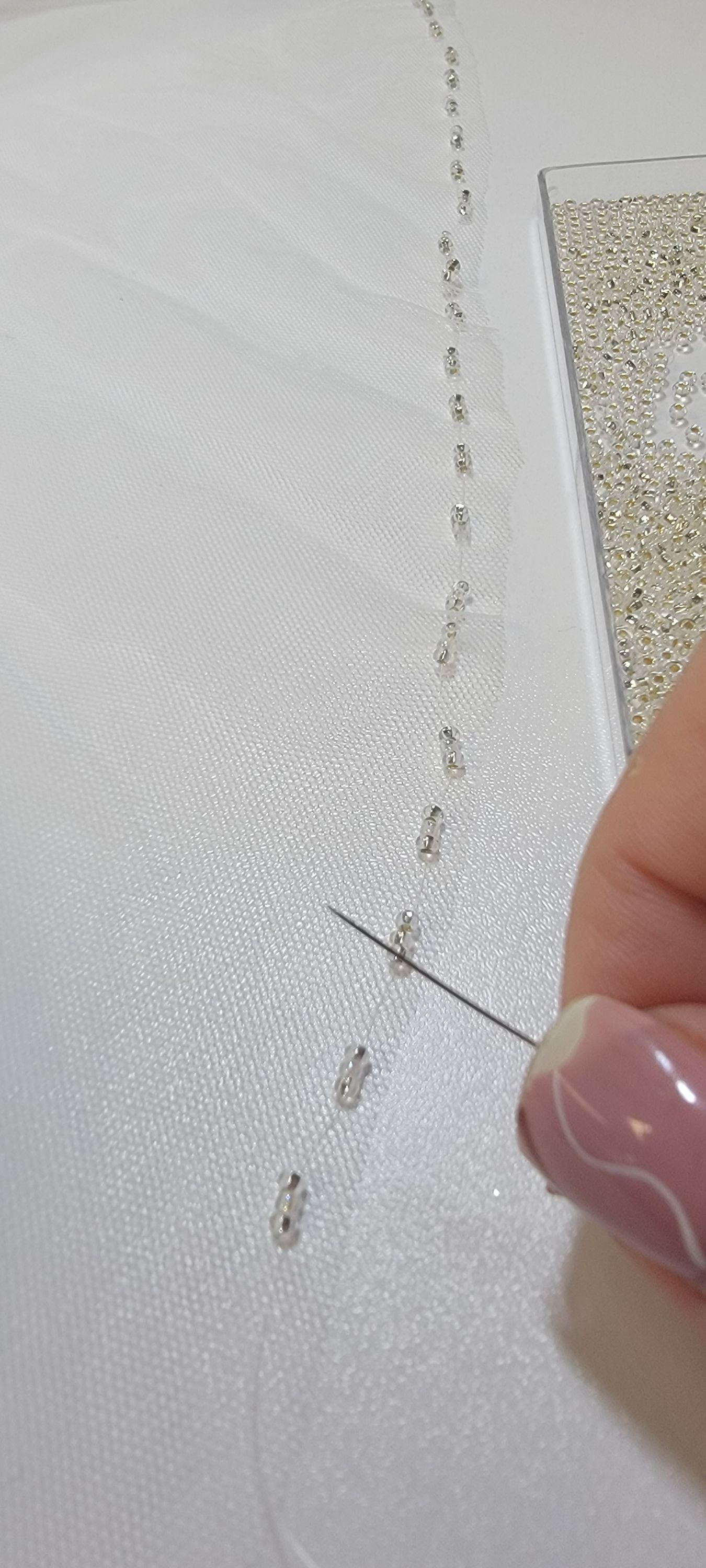 Close-up of hand beading on a wedding gown