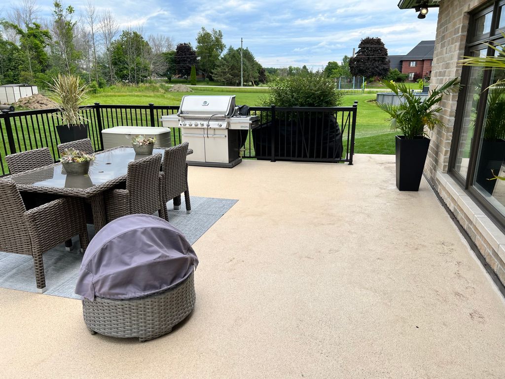 Outdoor residential patio with seamless beige polymer floor coating and patio furniture