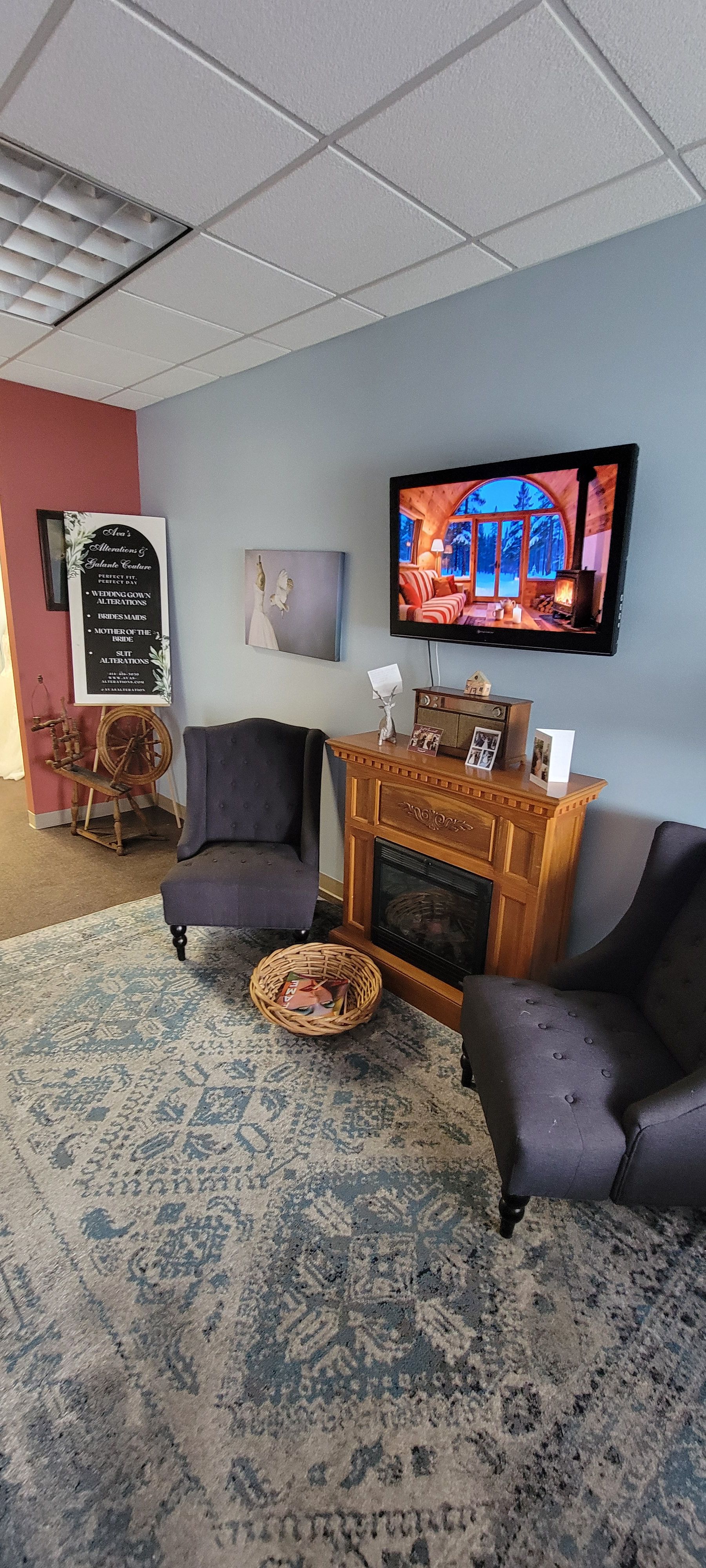 Cozy waiting area with fireplace and vintage spinning wheel